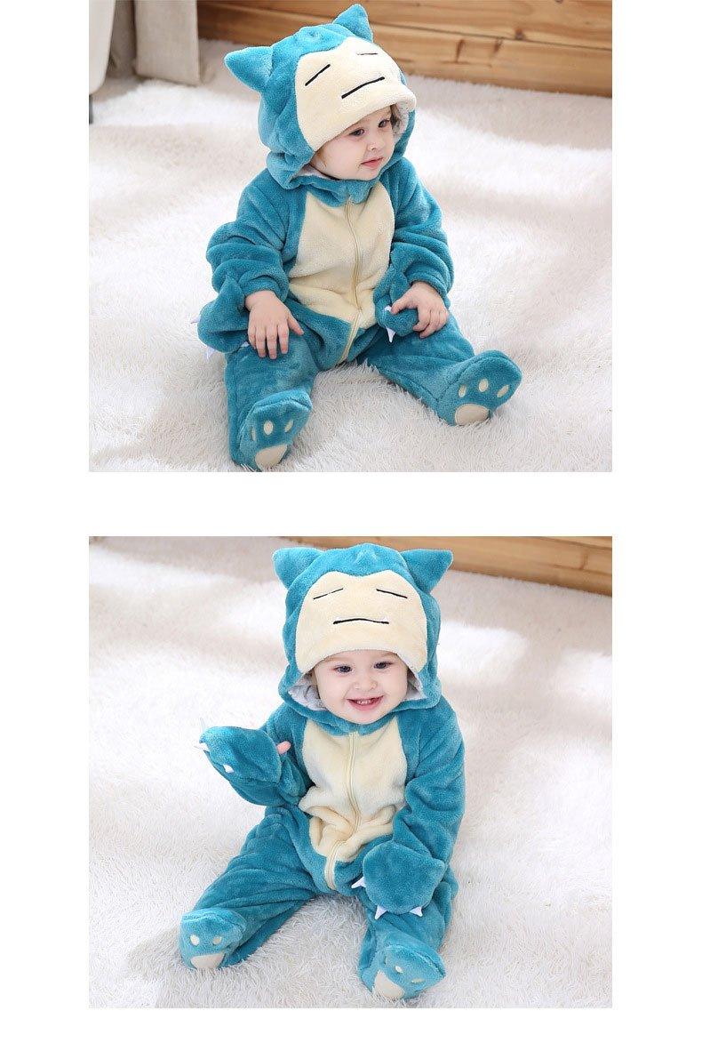 Baby in a blue Snorlax costume sitting on a white blanket.
