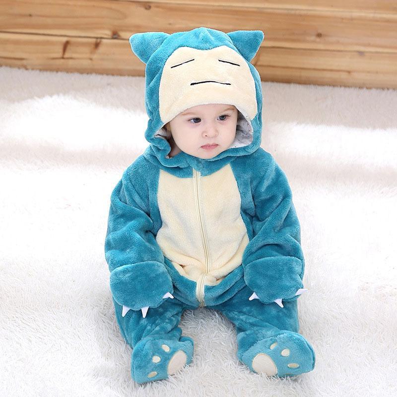 Child wearing a blue and white cartoon character onesie on a white surface.