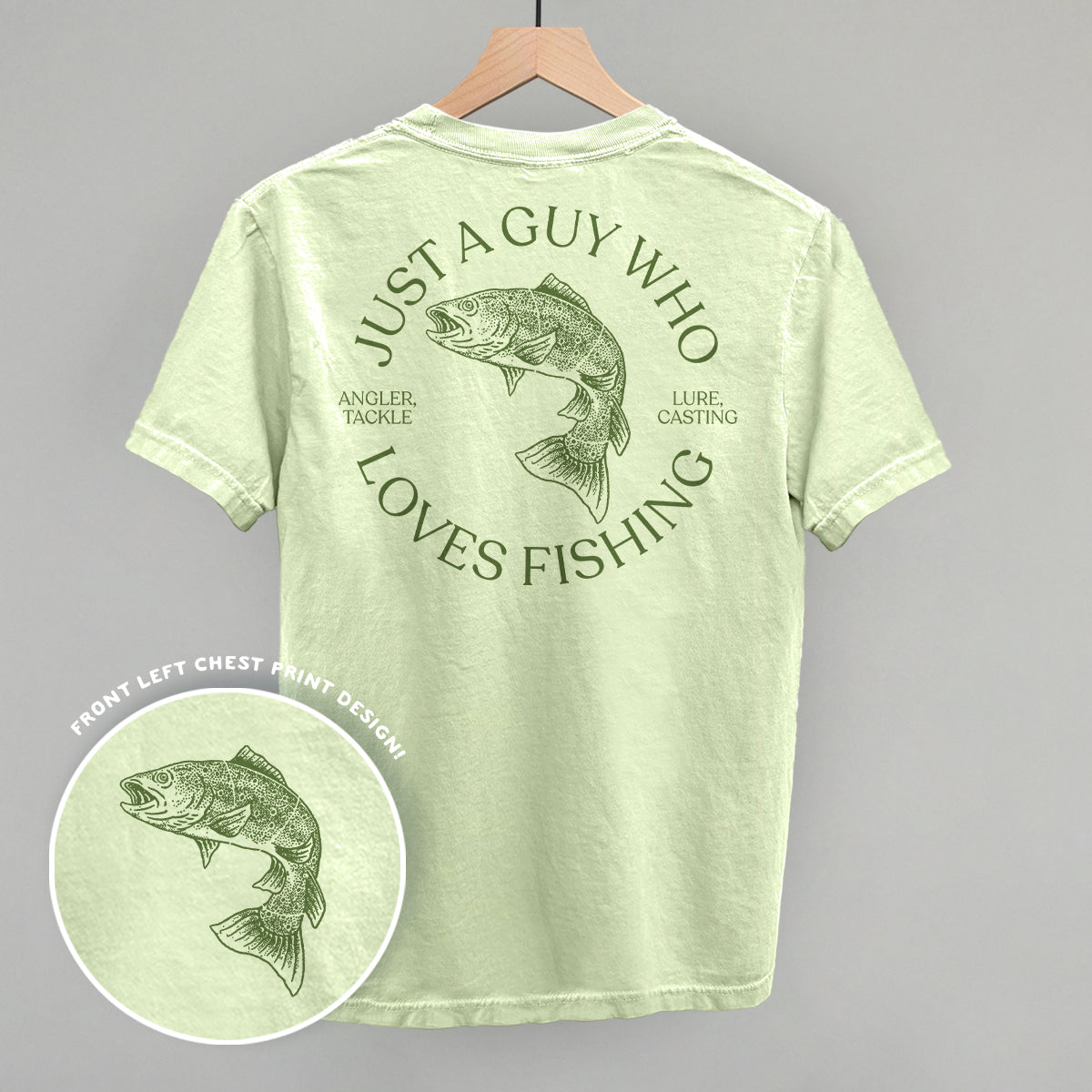 Light green t-shirt with fishing-themed design on a gray background