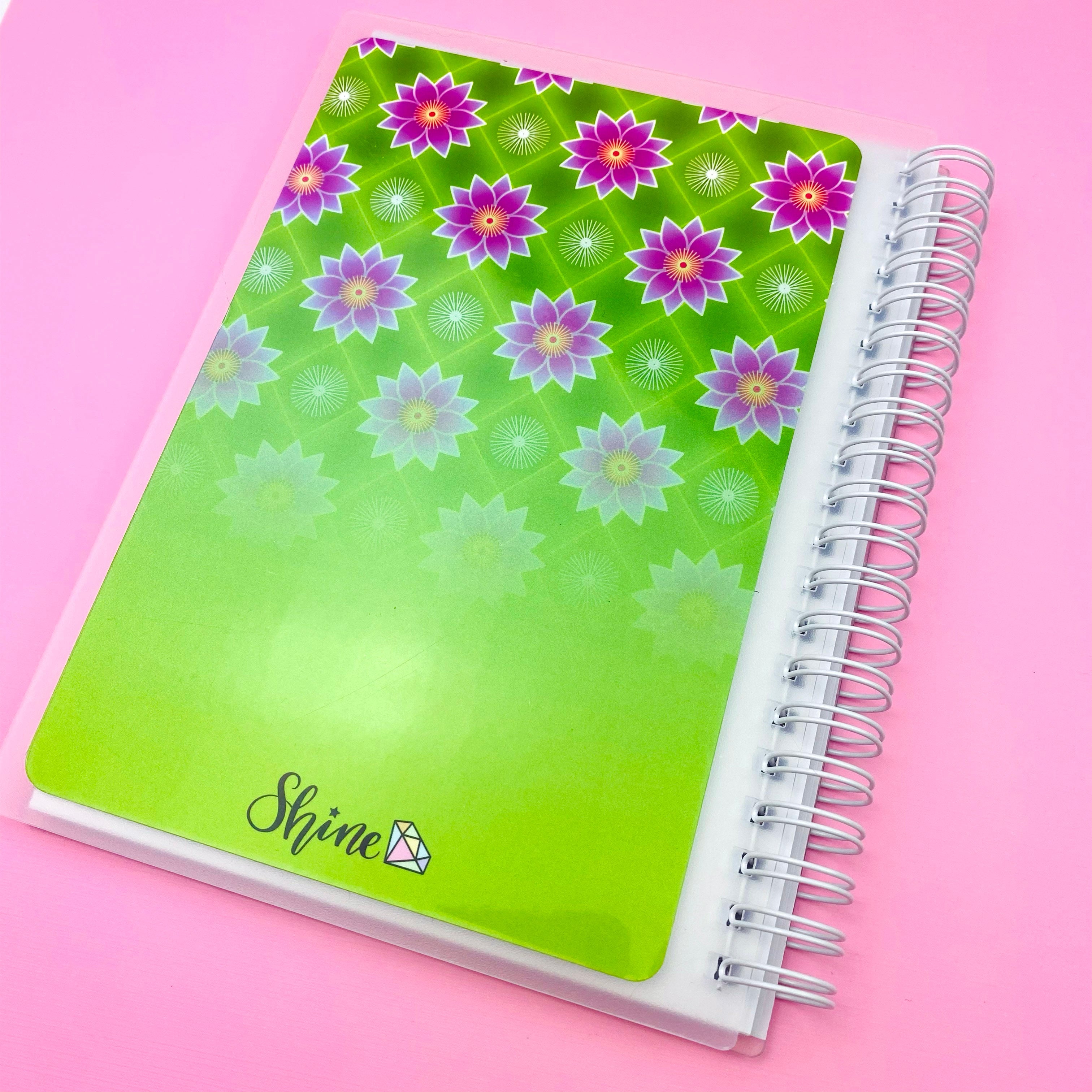 Notebook with floral design on a pink background