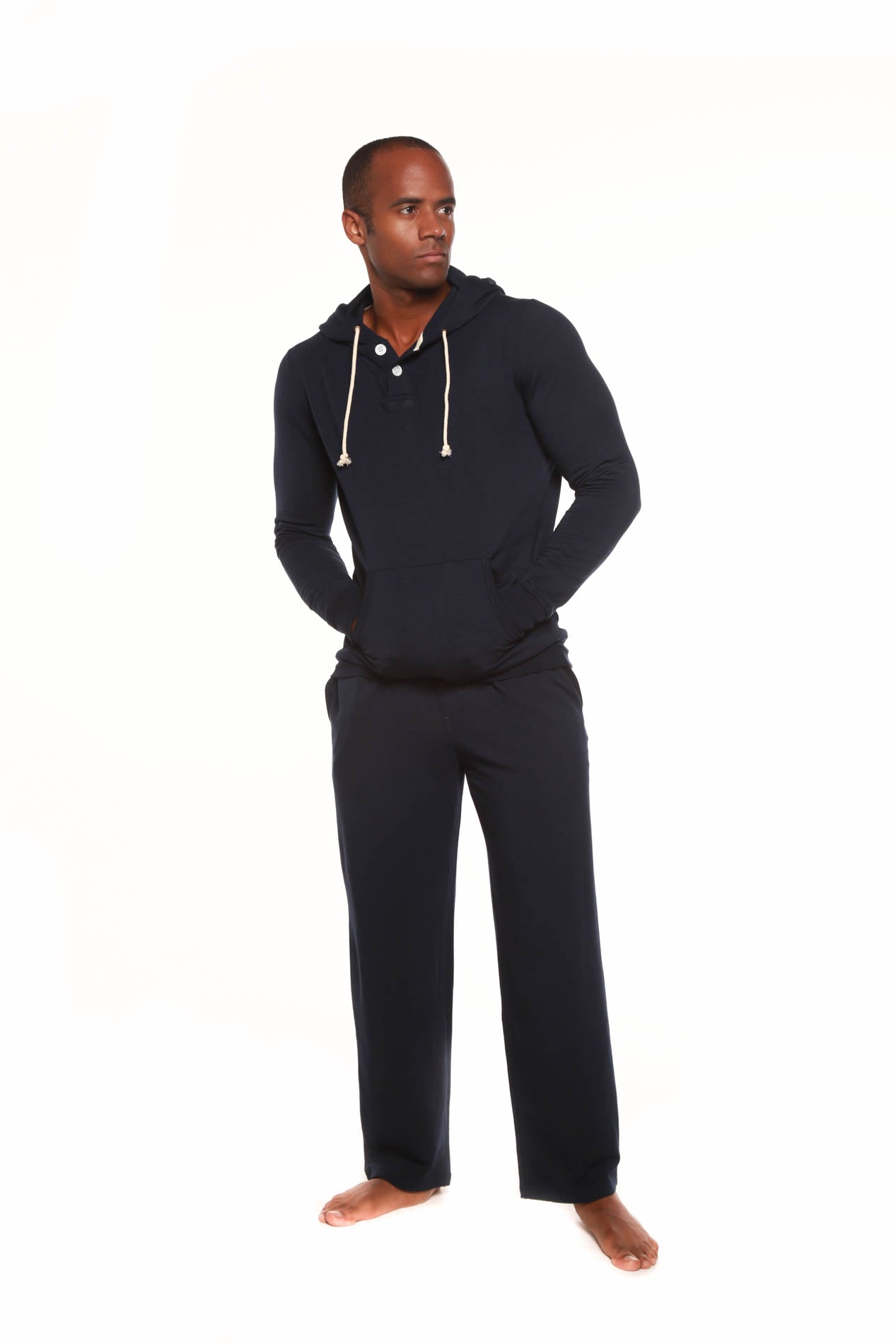 Man wearing a black hoodie and pants on a white background