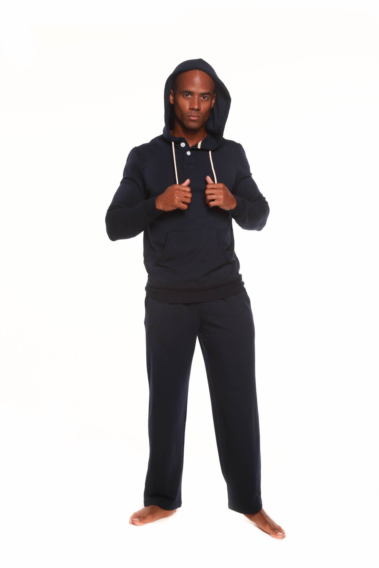 Man wearing a black hoodie and pants on a white background