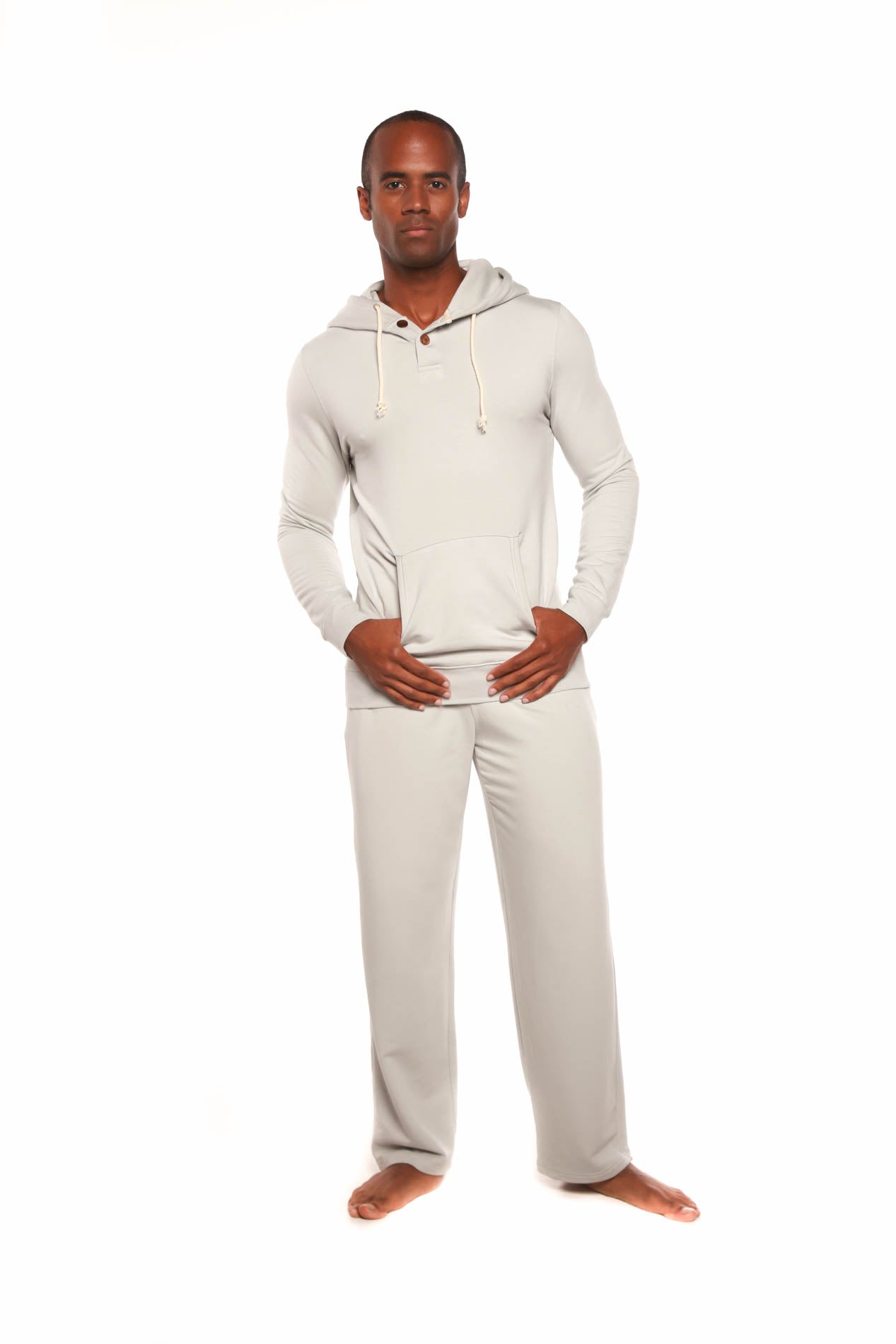 Man wearing a beige hoodie and pants on a white background