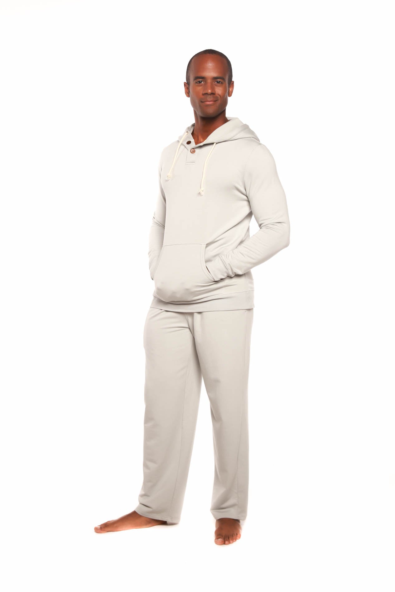 Man wearing a cream-colored hoodie and pants on a white background