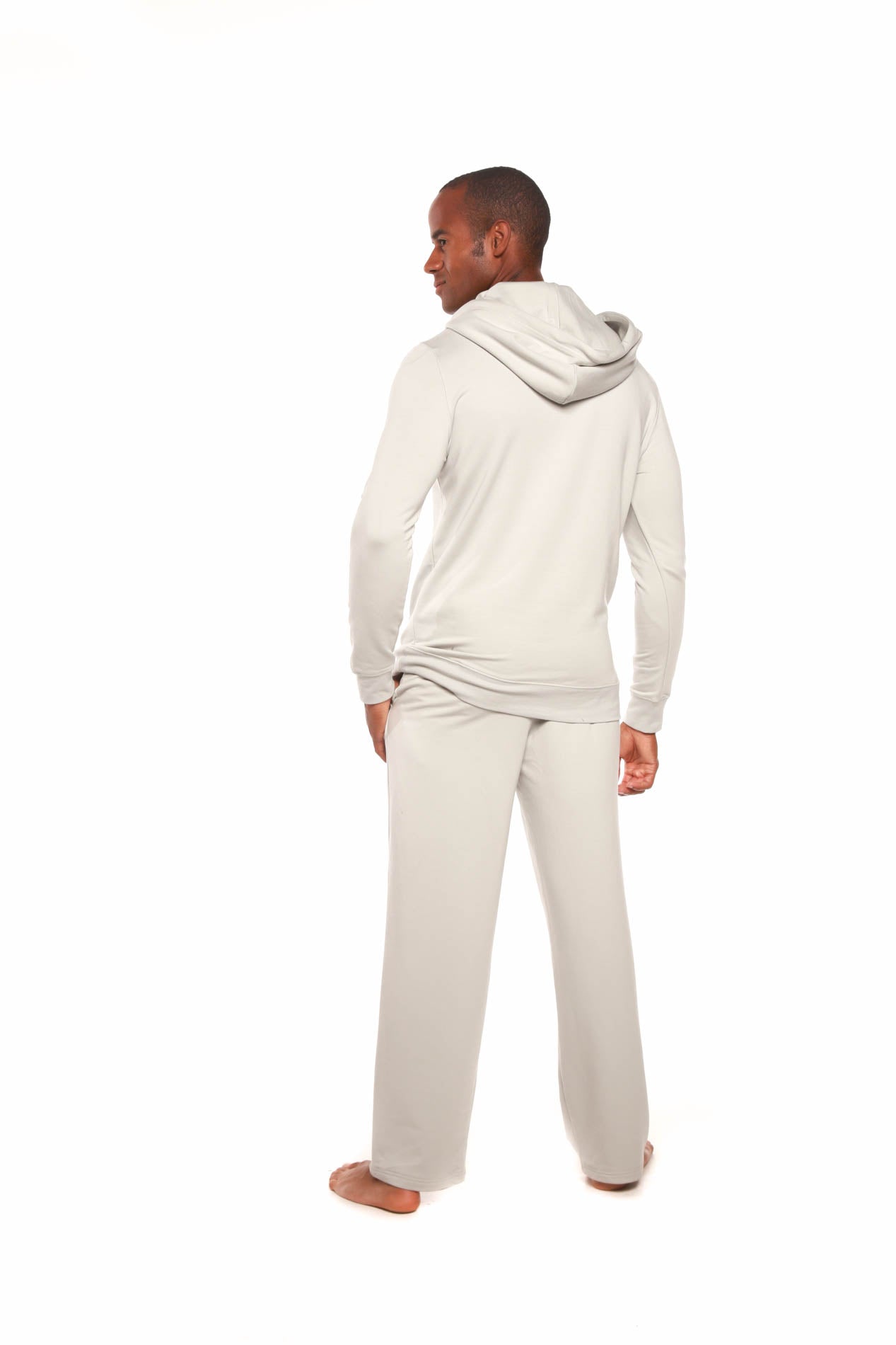 Person wearing a beige hoodie and pants on a white background