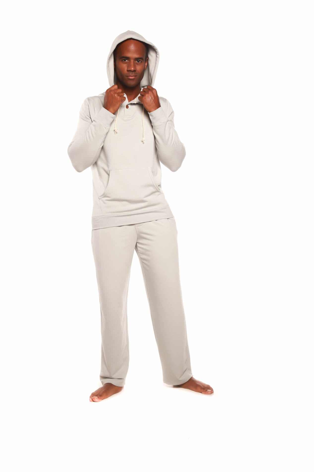 Man wearing a beige hoodie and pants on a white background