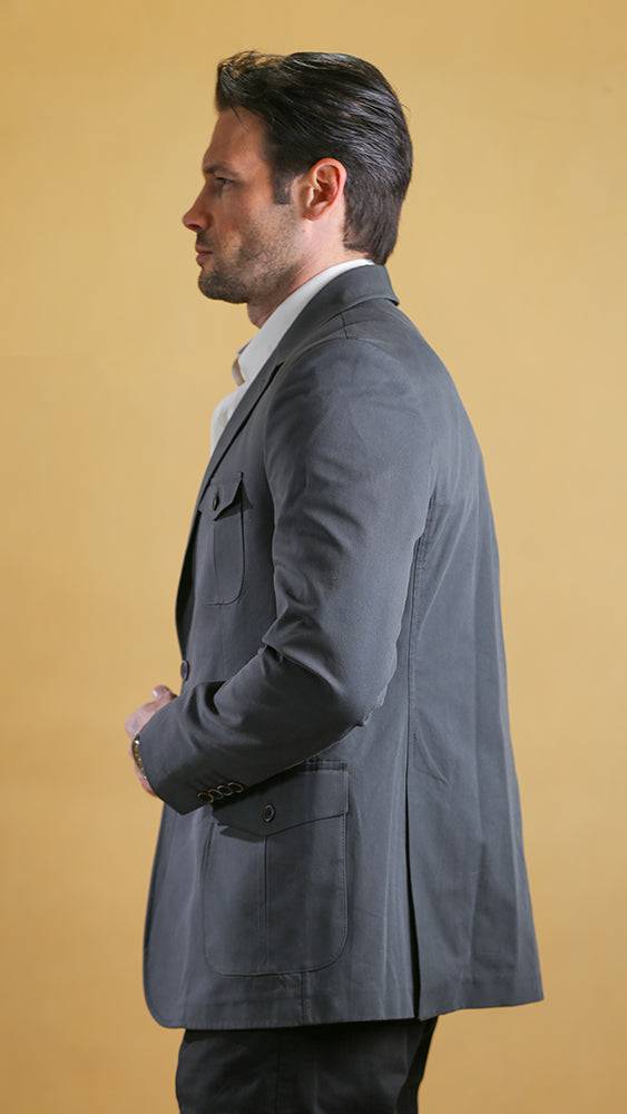 Man wearing a gray coat against a beige background
