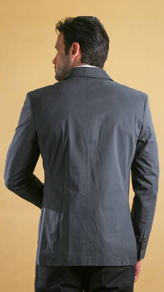 Man wearing a gray blazer against a beige background
