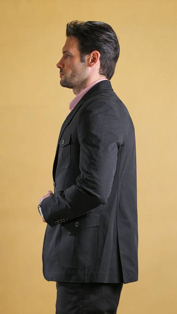 Man wearing a black jacket against a beige background