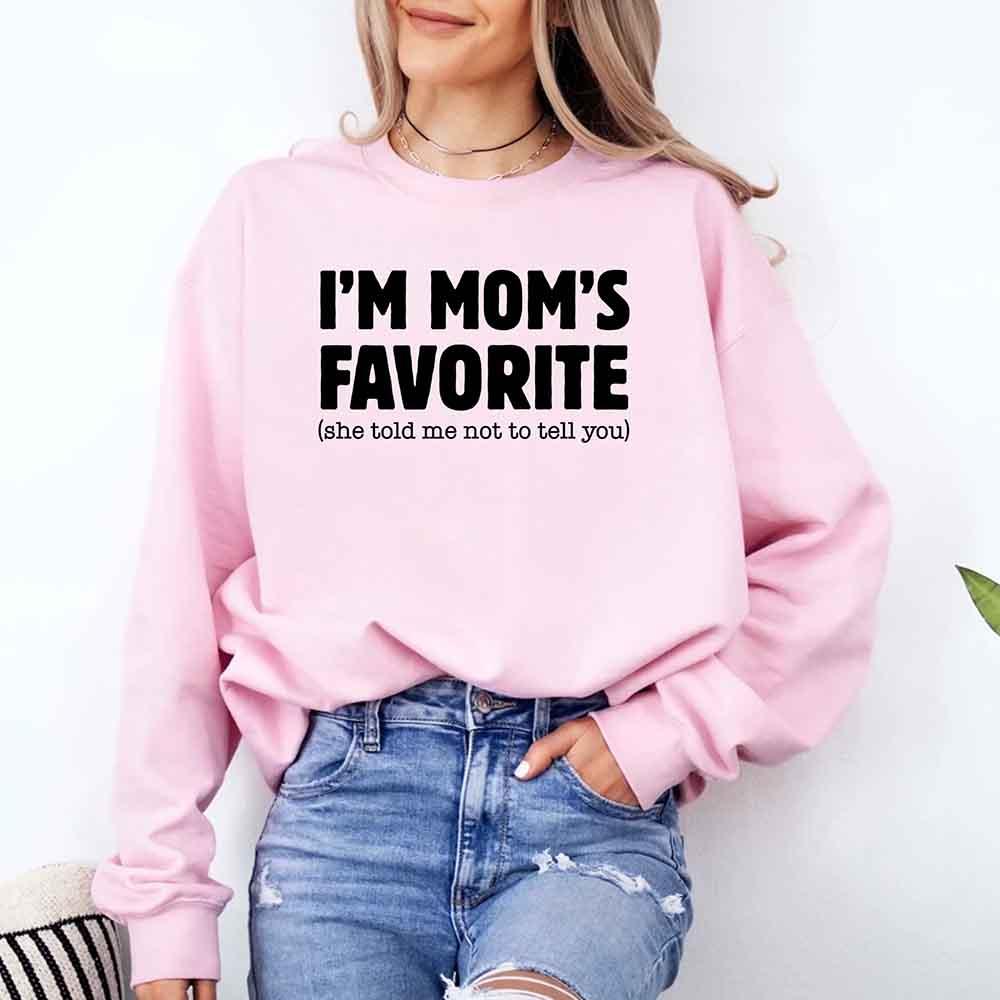 Person wearing a pink sweatshirt with text, standing against a white background