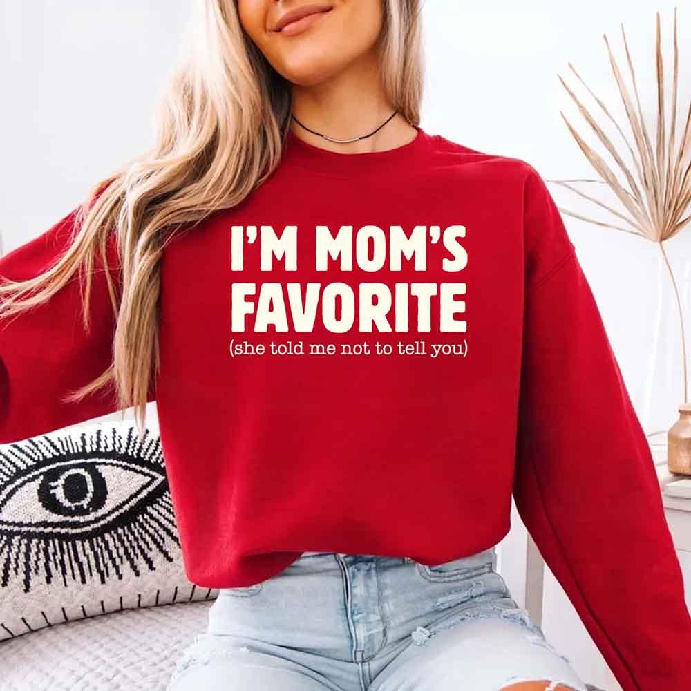 Person wearing a red sweatshirt with text, sitting on a couch.