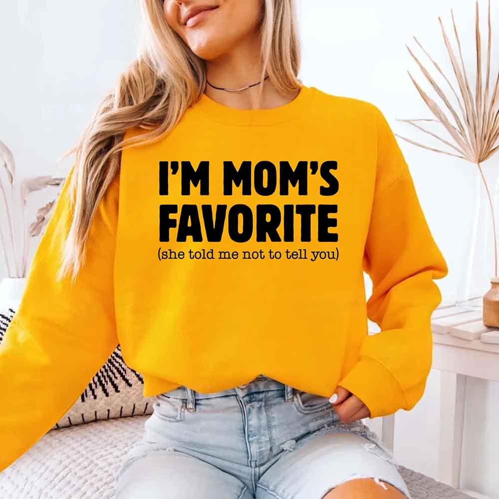 Person wearing a yellow sweatshirt with text in a home setting