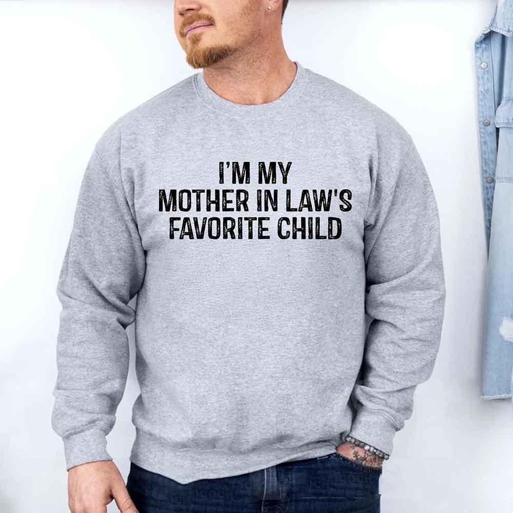 Person wearing a gray sweatshirt with text 'I'm my mother in law's favorite child' on a white background