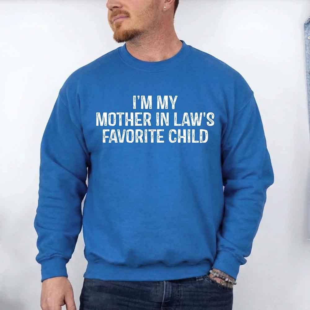 Person wearing a blue sweatshirt with text 'I'm my mother-in-law's favorite child' against a white background