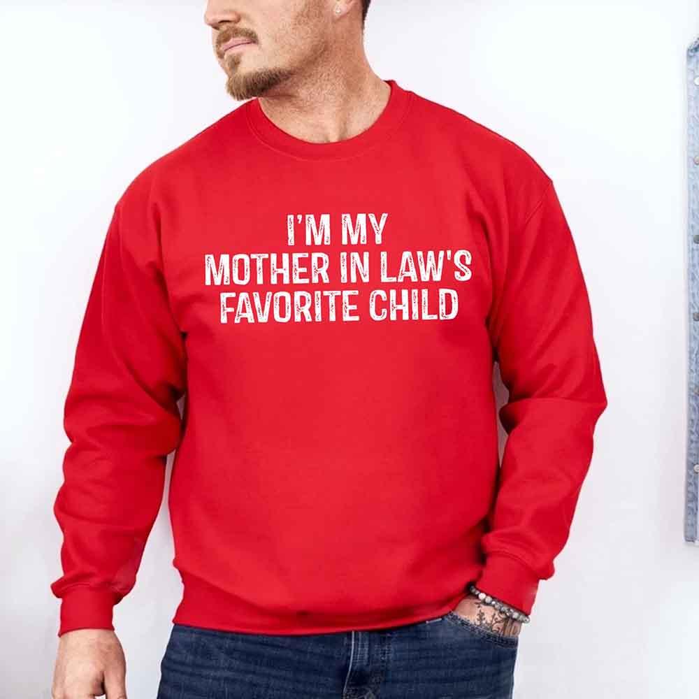 Red sweatshirt with text 'I'm my mother in law's favorite child' worn by a person on a white background