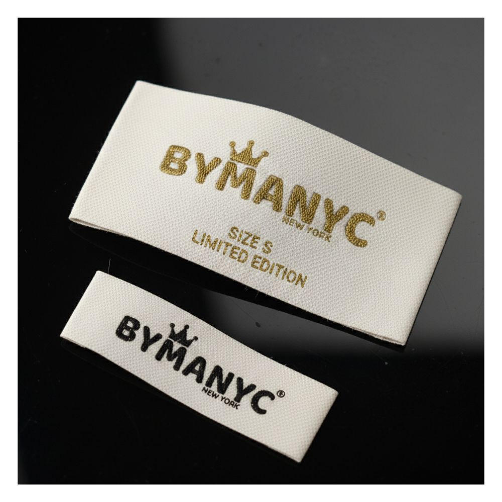Two BYMANYC New York labels on a dark background