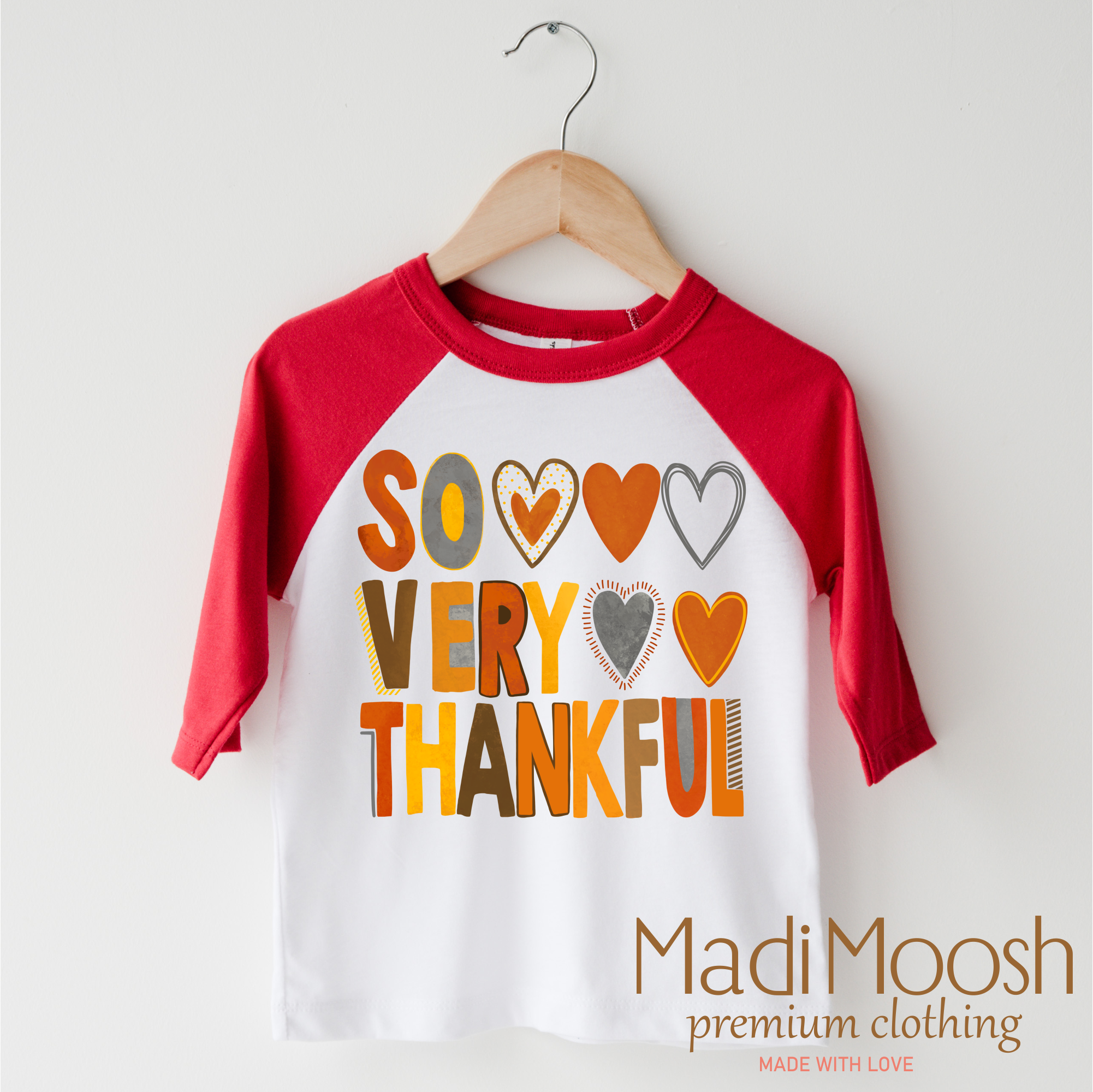 Children's 3/4 sleeve shirt with 'So Very Thankful' text and red sleeves on a hanger, branded as Madi Moosh.