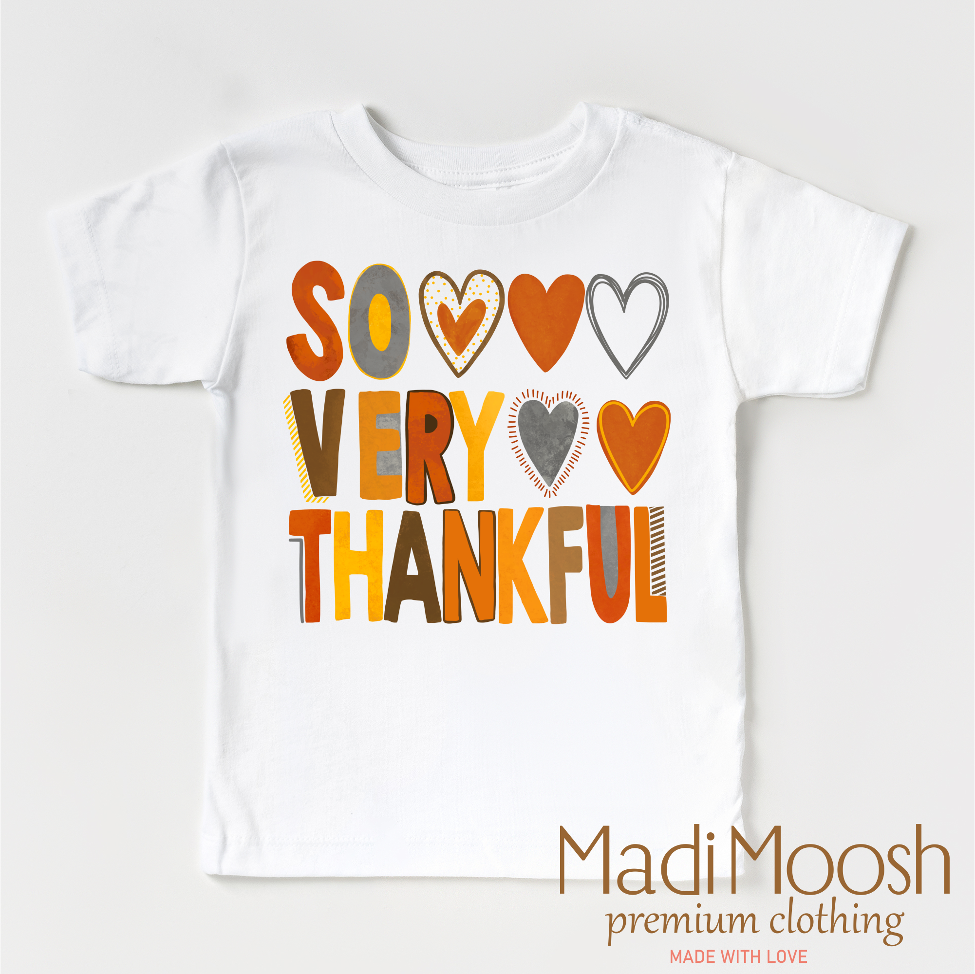 White t-shirt with colorful text 'SO VERY THANKFUL' and Madi Moosh branding on a white background