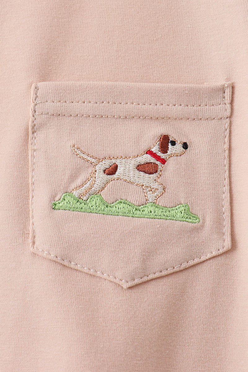 Embroidered dog design on a pocket of a light pink shirt