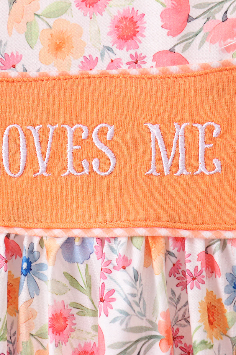 Floral fabric with an orange strip displaying 'LOVES ME' text