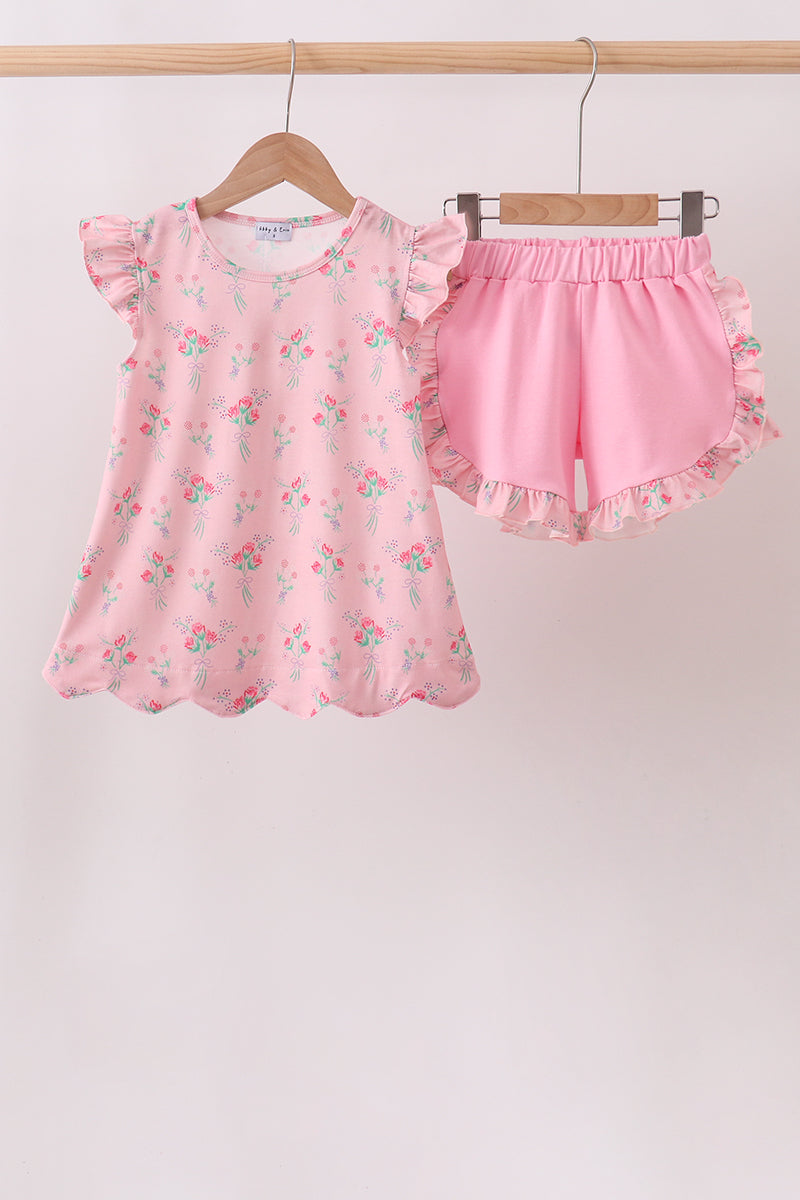 Pink children's outfit with floral pattern on a white background