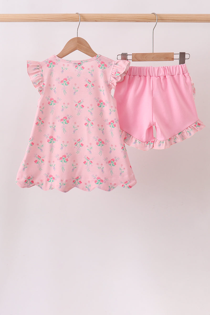 Pink children's outfit with floral pattern on a white background