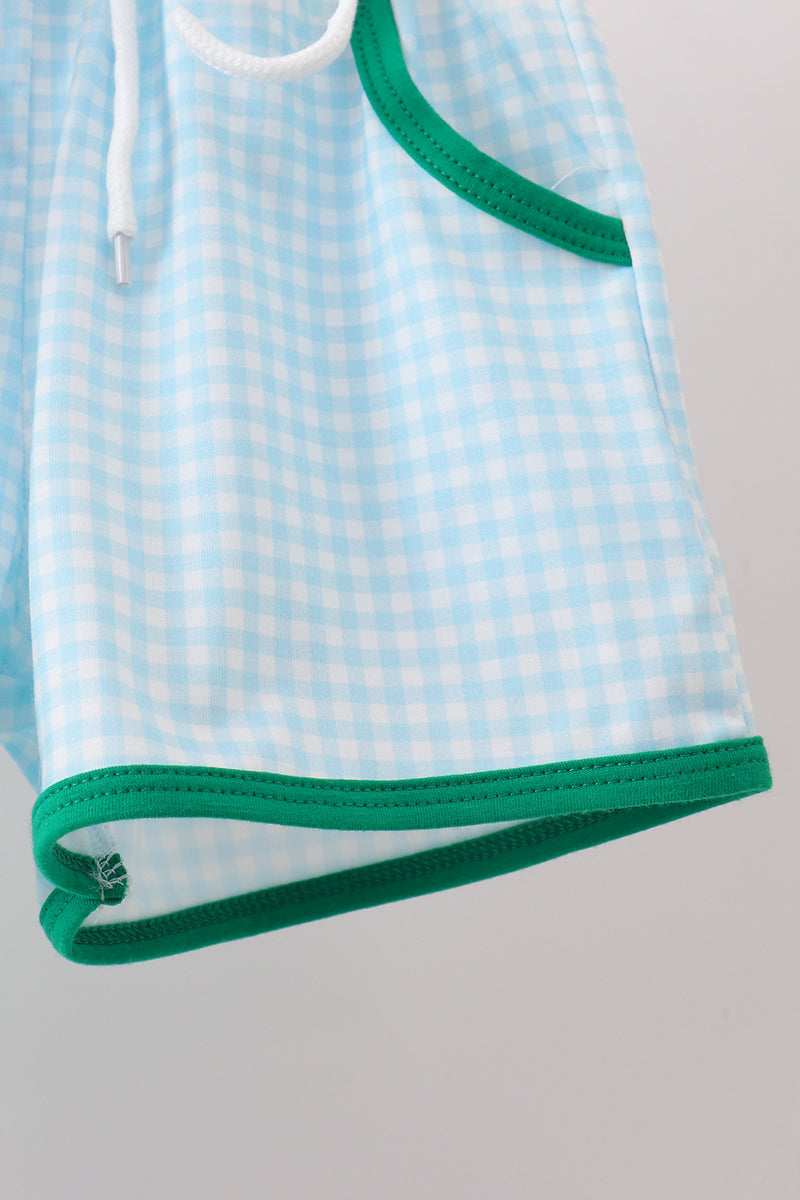 Light blue checkered shorts with green trim on a gray background