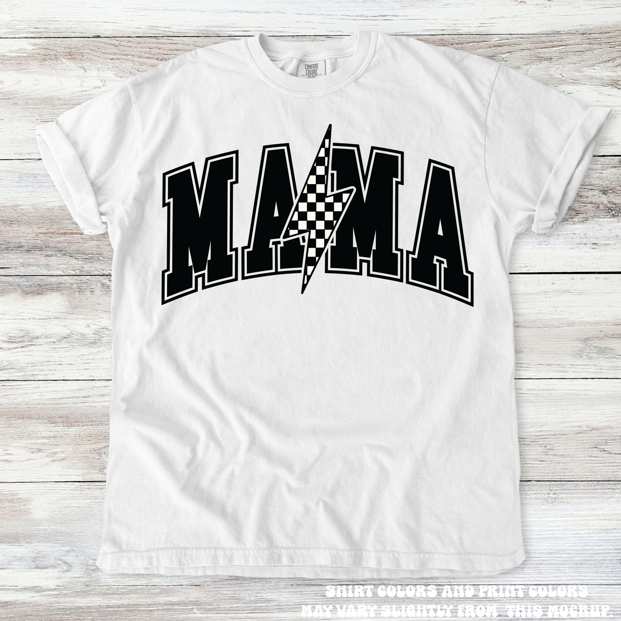 White t-shirt with 'MAMA' text and checkered flag design on a wooden surface