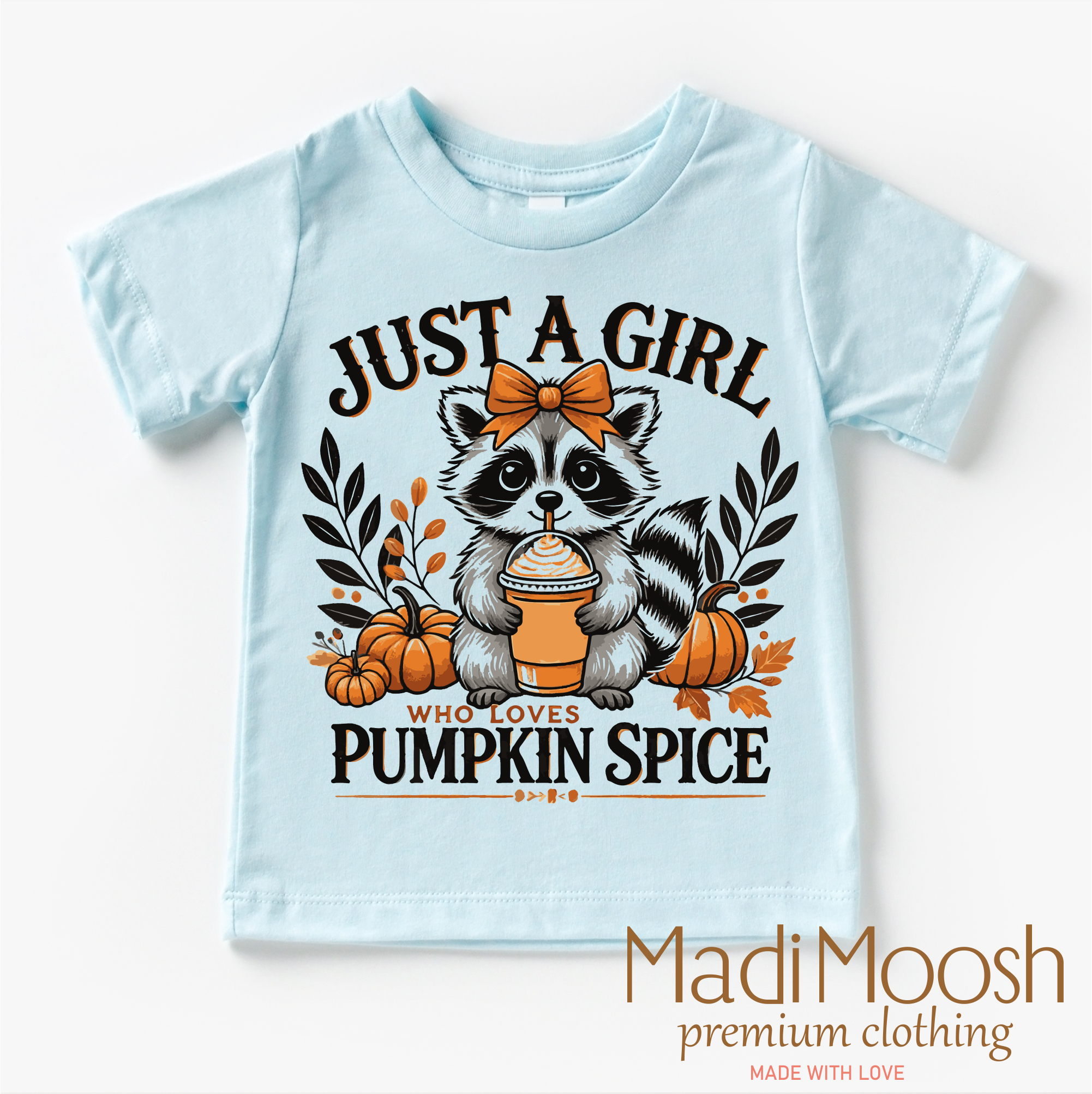 Light blue t-shirt with a raccoon graphic and text 'Just a girl who loves pumpkin spice' on a white background.