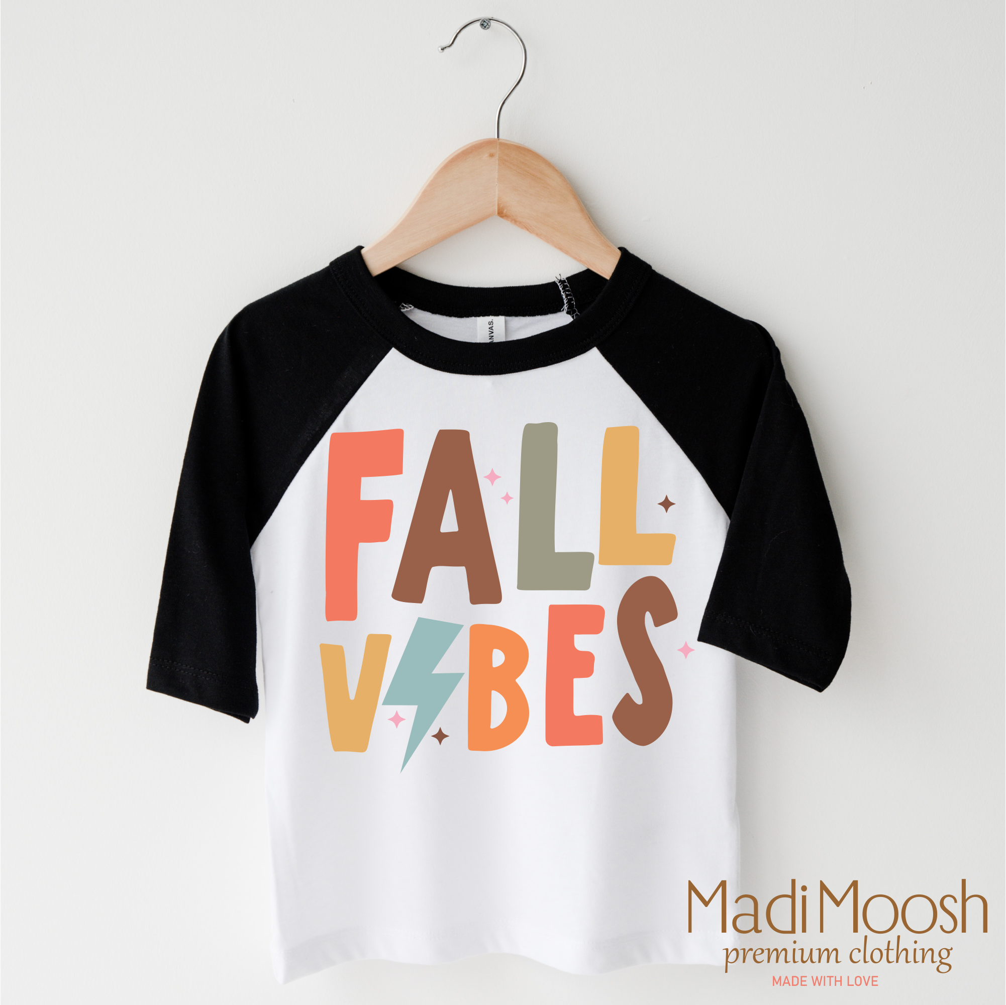 Children's 3/4 sleeve shirt with 'Fall Vibes' text on a hanger, featuring the brand 'Madi Moosh'.