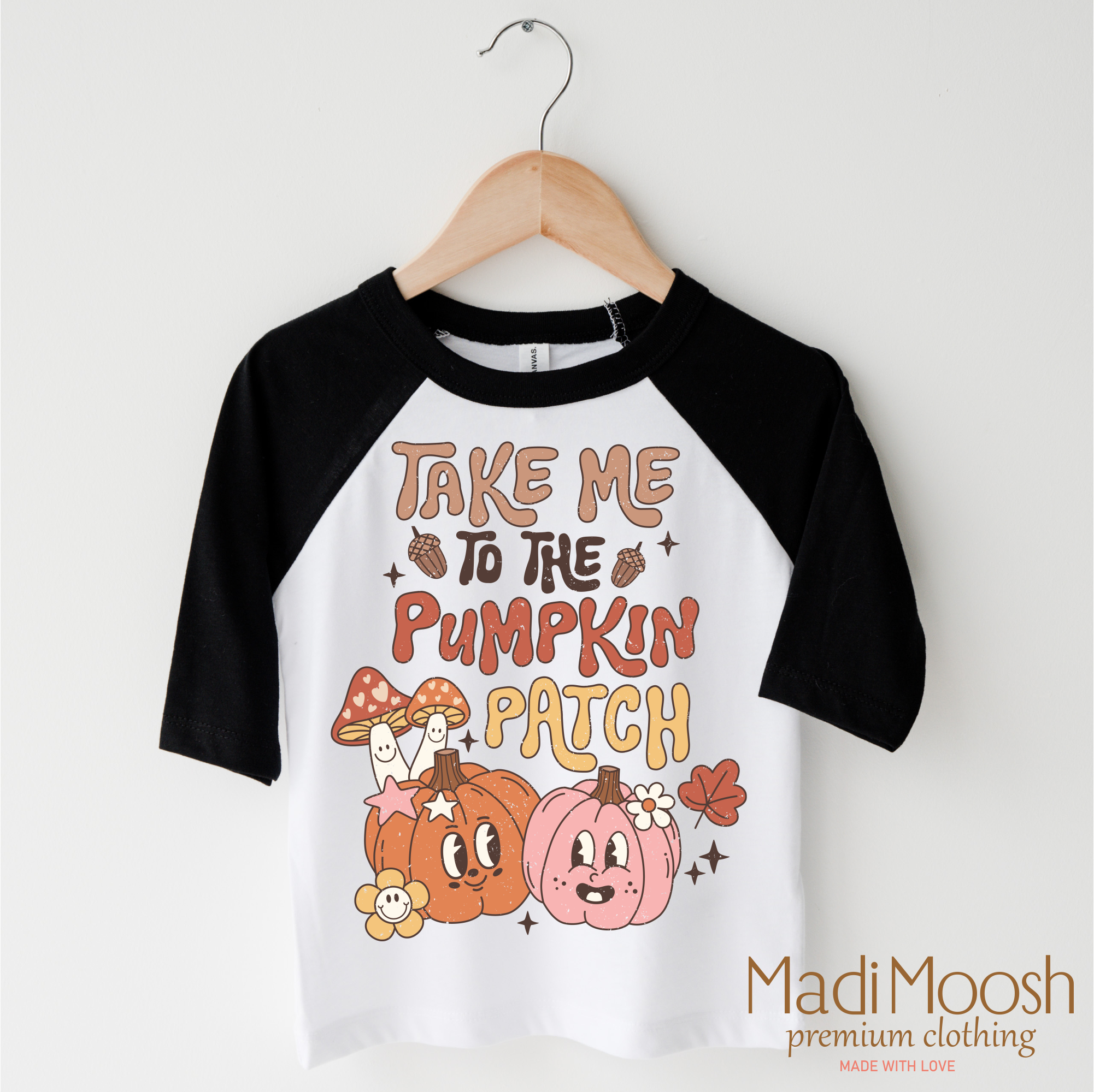 Children's 3/4 sleeve shirt with pumpkin patch design on a hanger