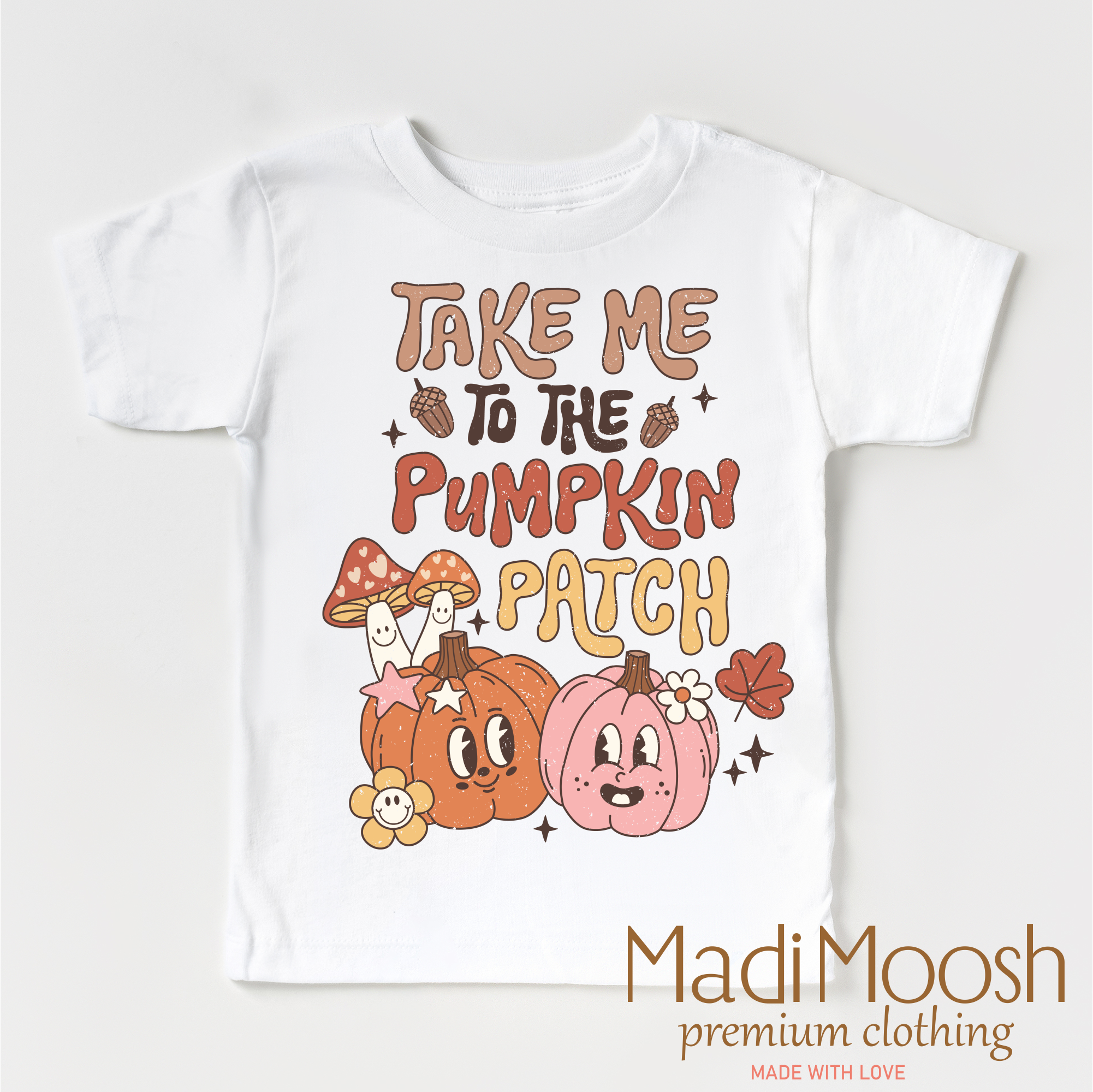 White t-shirt with 'Take Me to the Pumpkin Patch' text and cartoon pumpkins on a white background, featuring the brand 'Madi Moosh'.