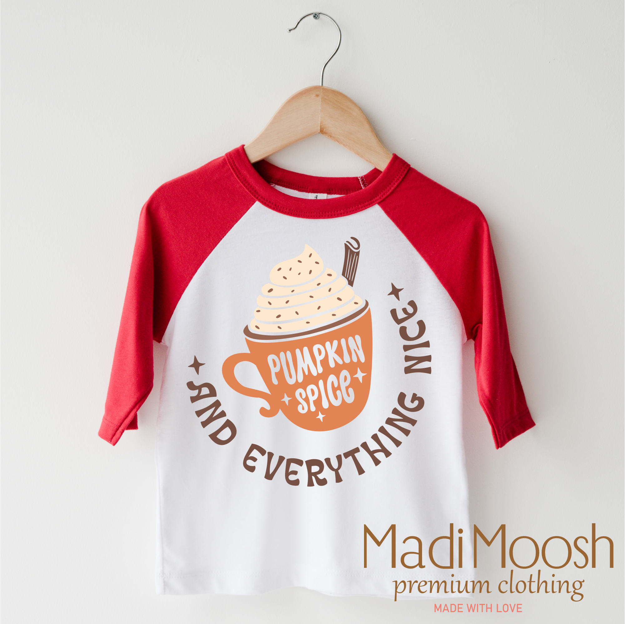 Children's 3/4 sleeve shirt with pumpkin spice design on a hanger, featuring the brand 'Madi Moosh'.