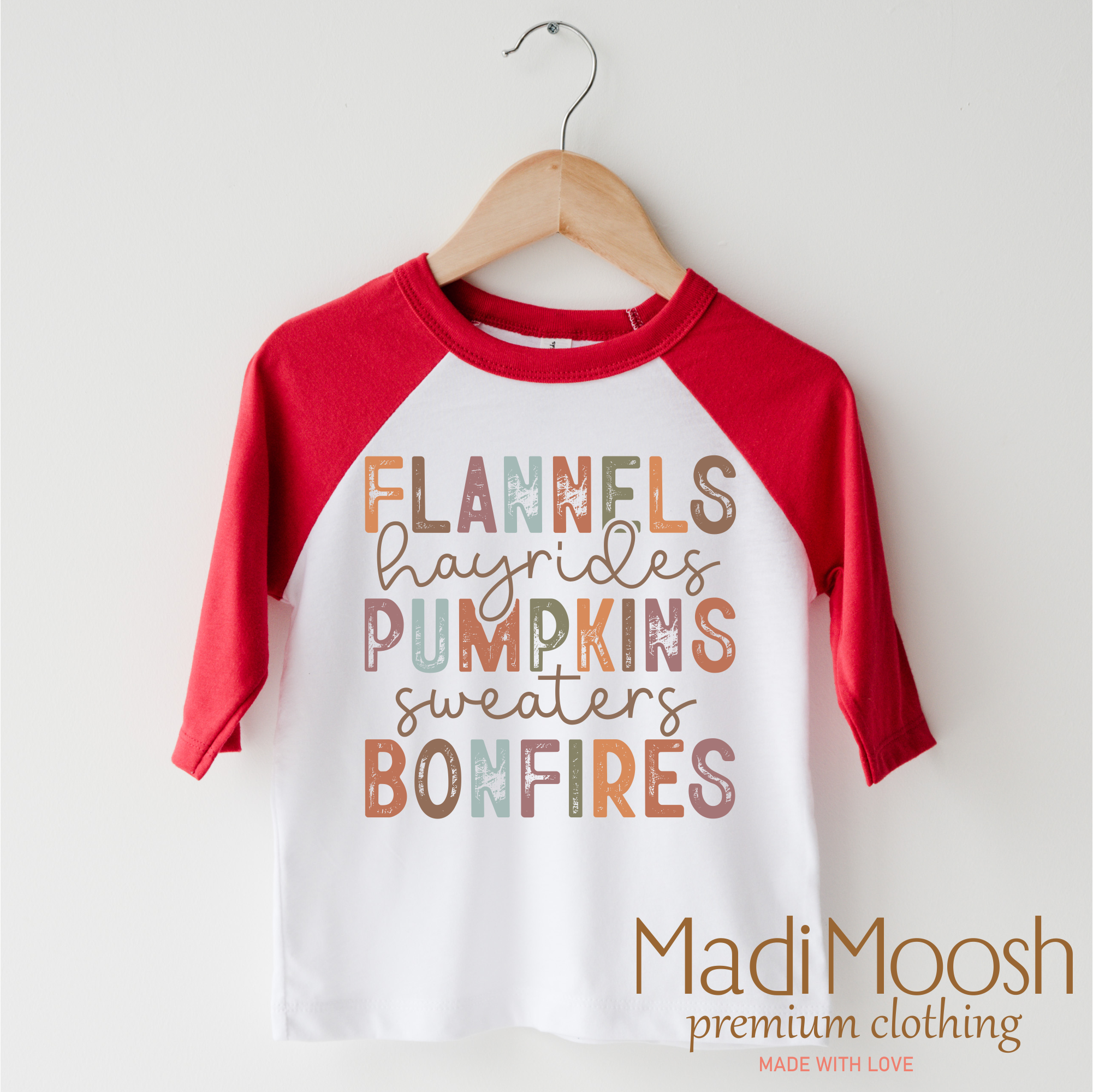 Children's 3/4 sleeve shirt with autumn-themed text on a hanger, featuring the brand 'Madi Moosh'.