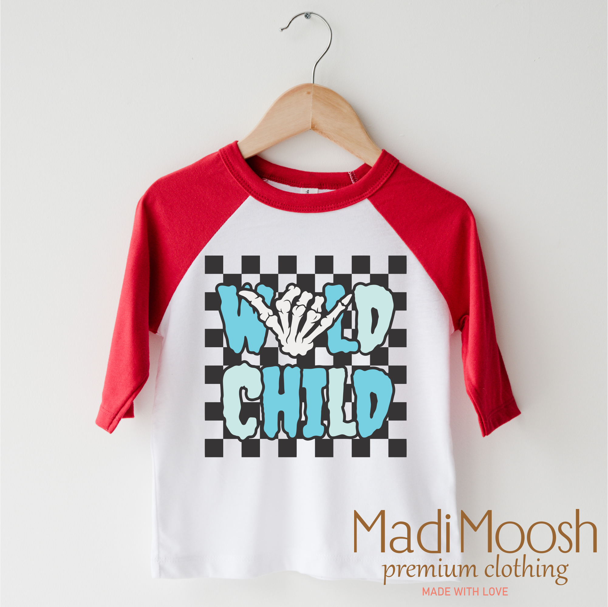 Red and white baseball 3/4 sleeve shirt with 'Wild Child' design on a hanger, branded as Madi Moosh.