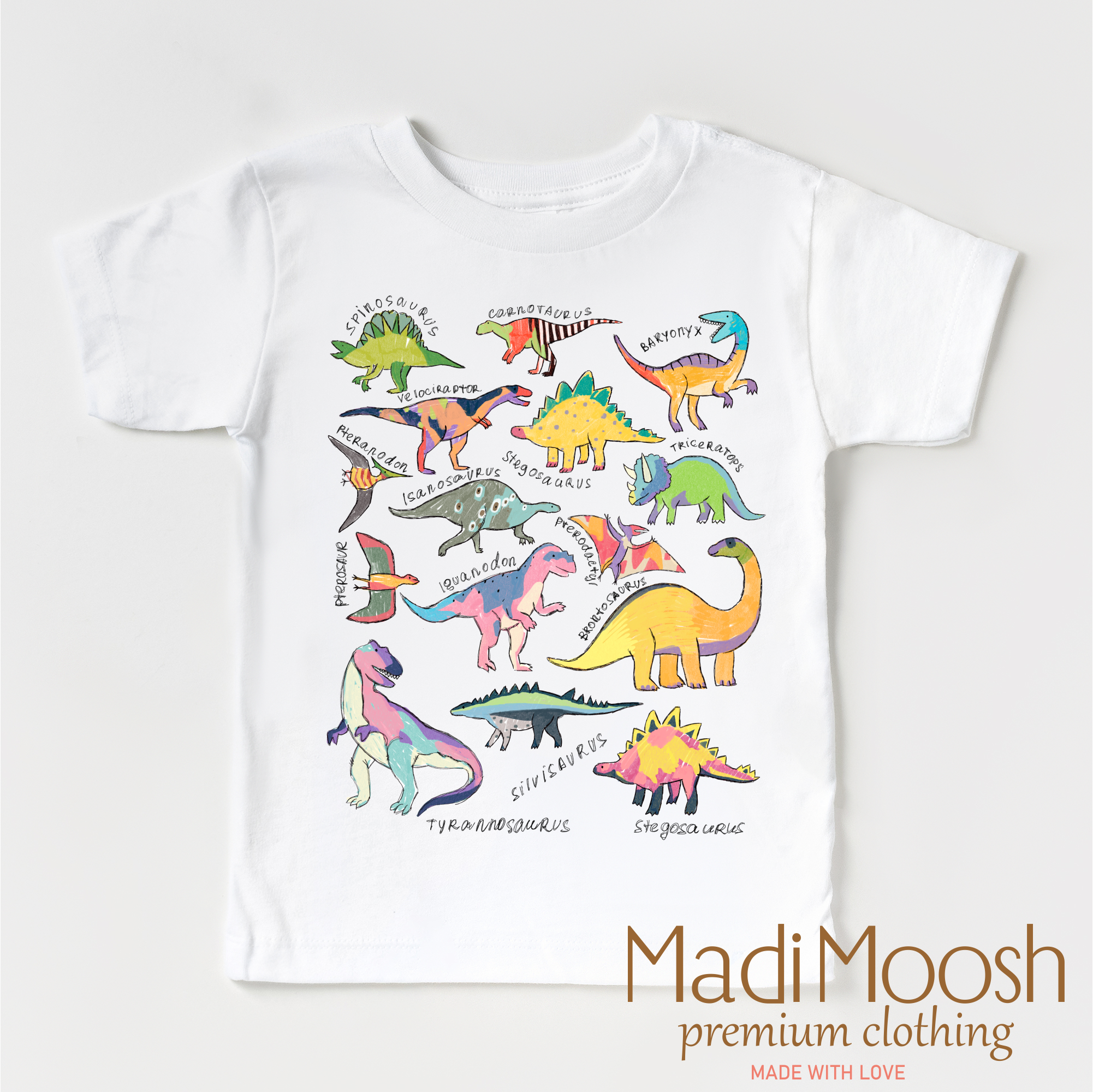 White t-shirt with colorful dinosaur illustrations and 'Madi Moosh' branding on a white background