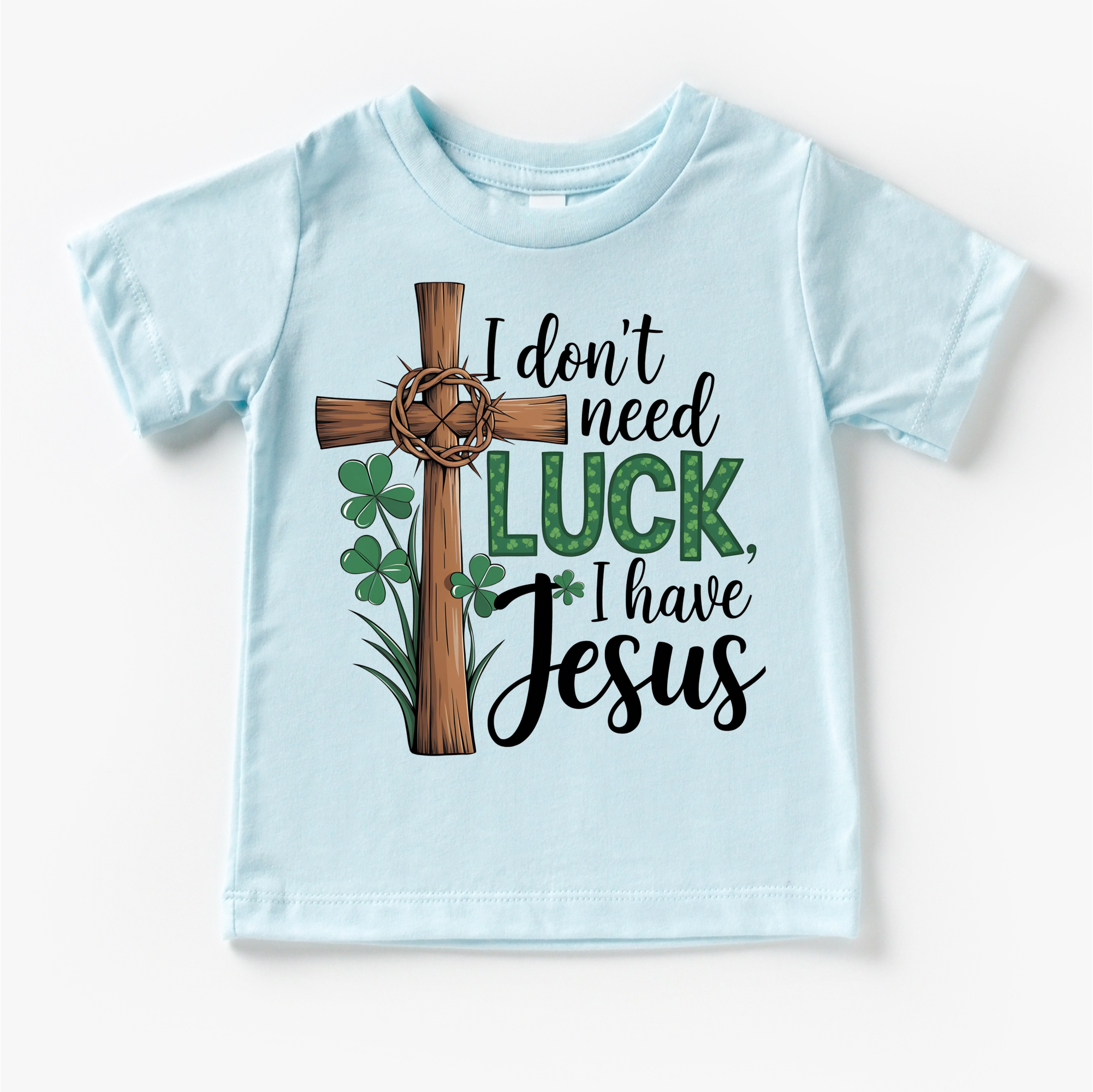 Light blue t-shirt with a cross, shamrocks, and text 'I don't need luck, I have Jesus' on a white background.