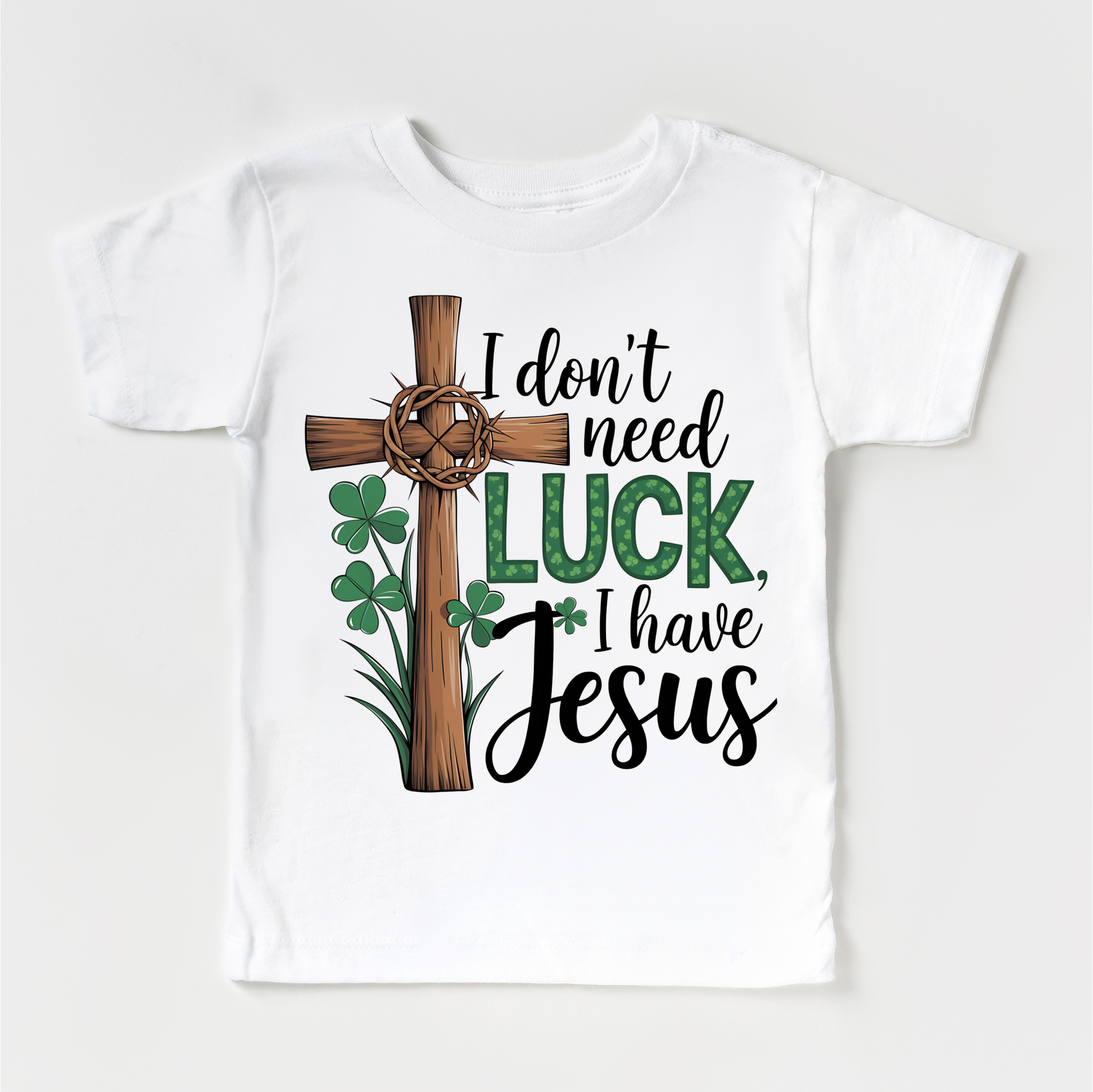 White t-shirt with a cross, shamrocks, and text 'I don't need luck, I have Jesus' on a white background