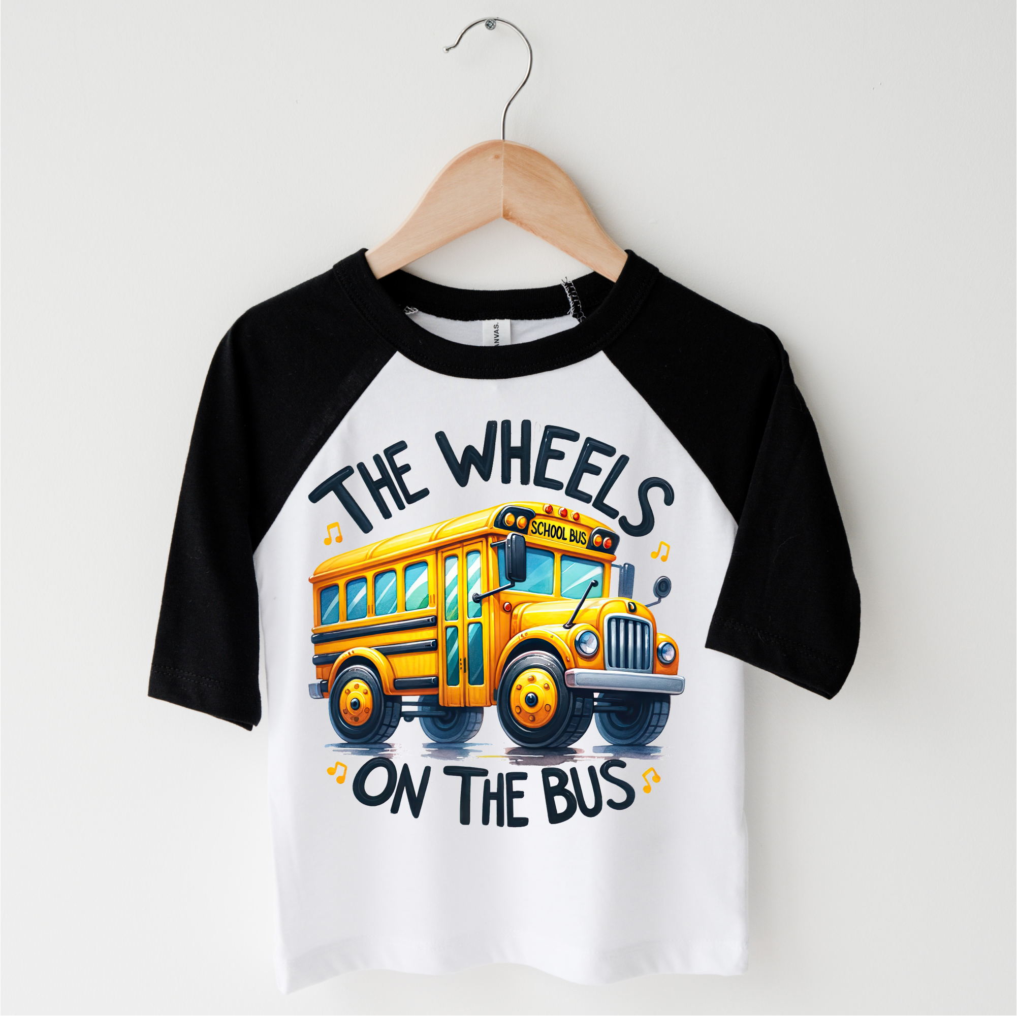Children's t-shirt with a yellow school bus graphic and text on a white background