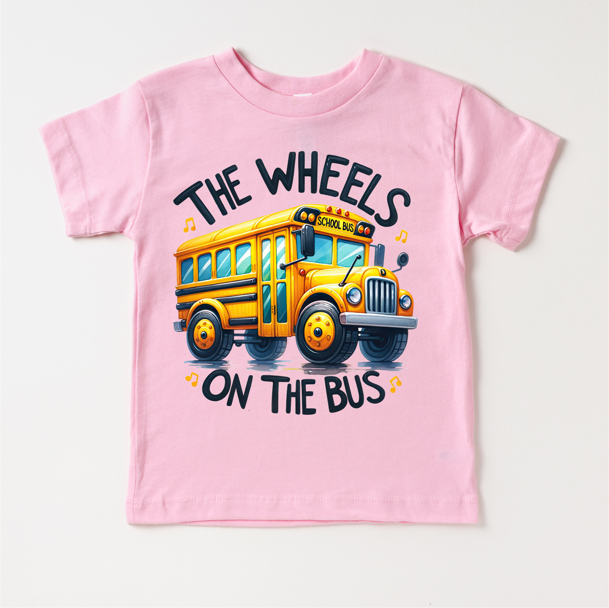 Pink children's t-shirt with a yellow school bus graphic and text on a white background