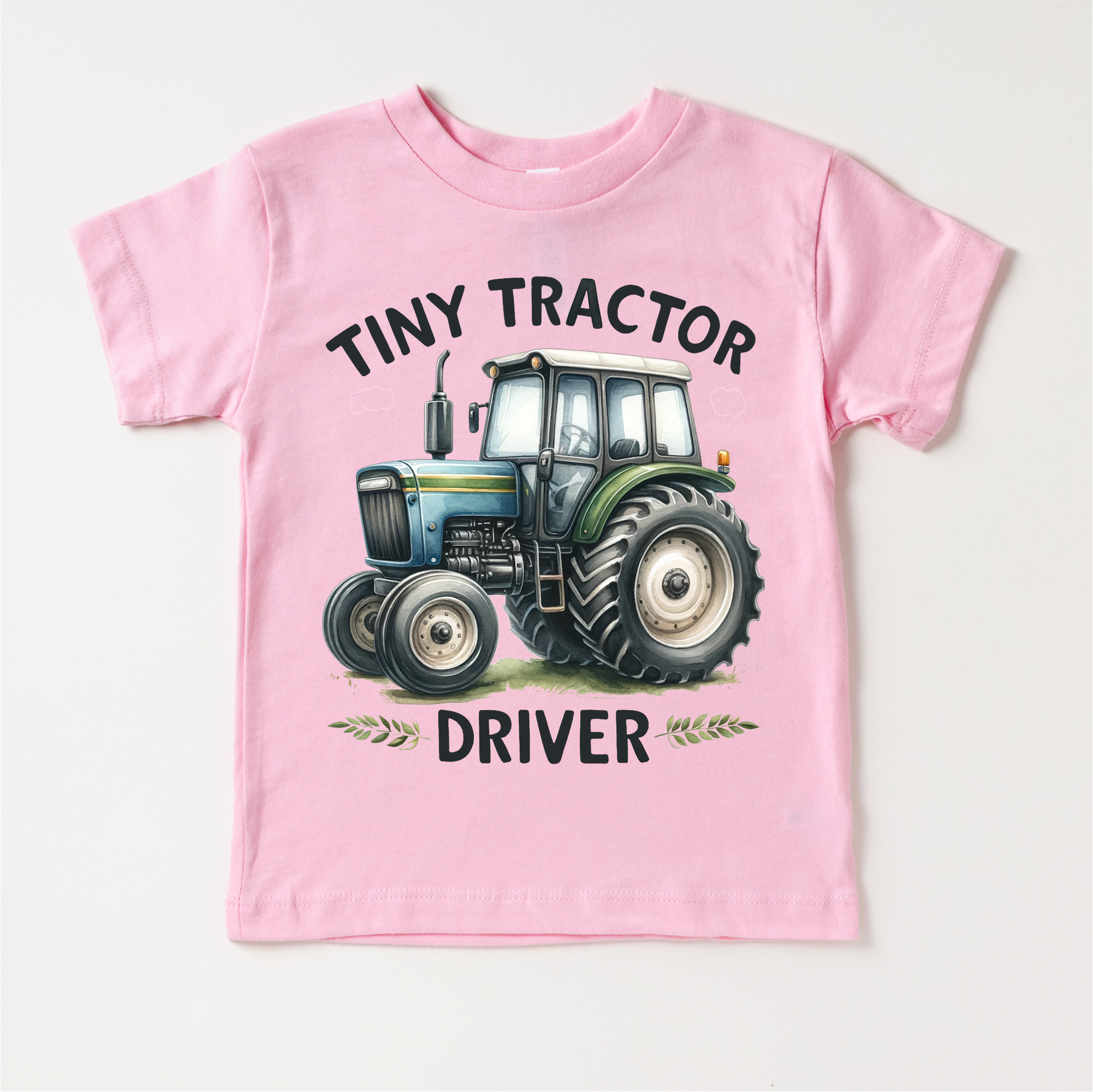 Pink t-shirt with a tractor graphic and text on a white background