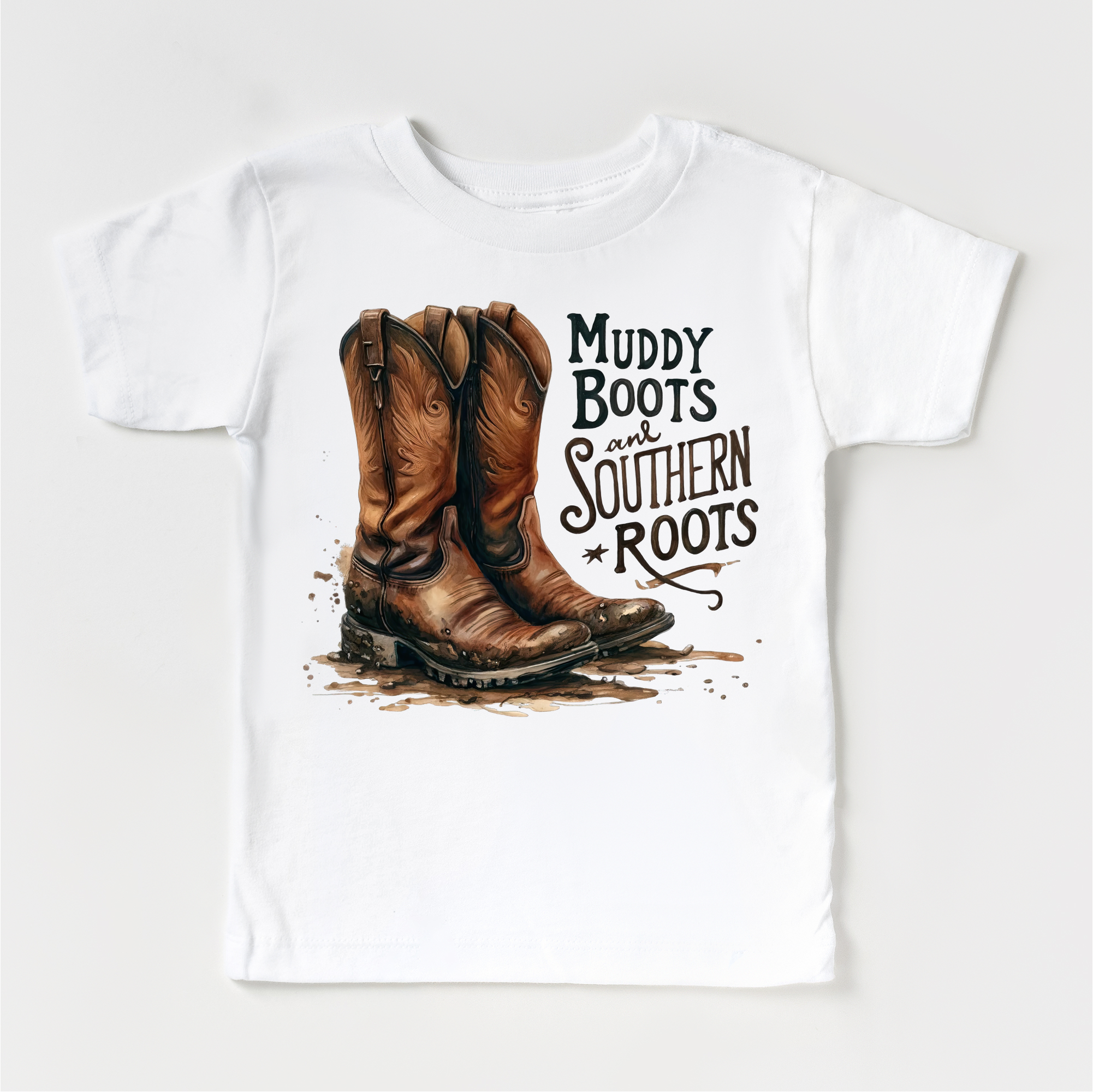 White t-shirt with brown cowboy boots and 'Muddy Boots and Southern Roots' text on a white background