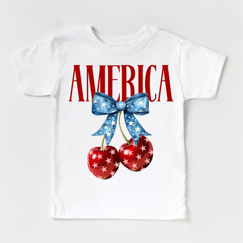 White t-shirt with 'AMERICA' text, cherries, and a bow on a white background