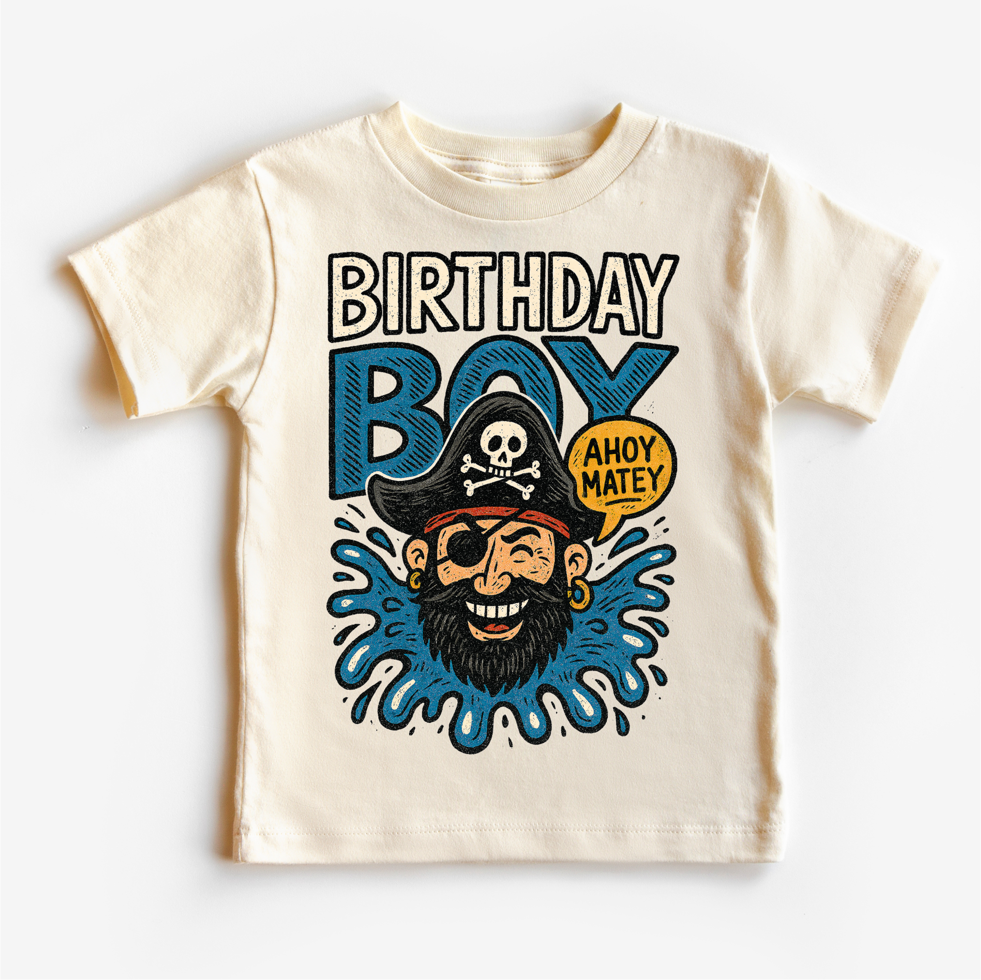 Beige t-shirt with a pirate-themed design and 'Birthday Boy' text on a white background