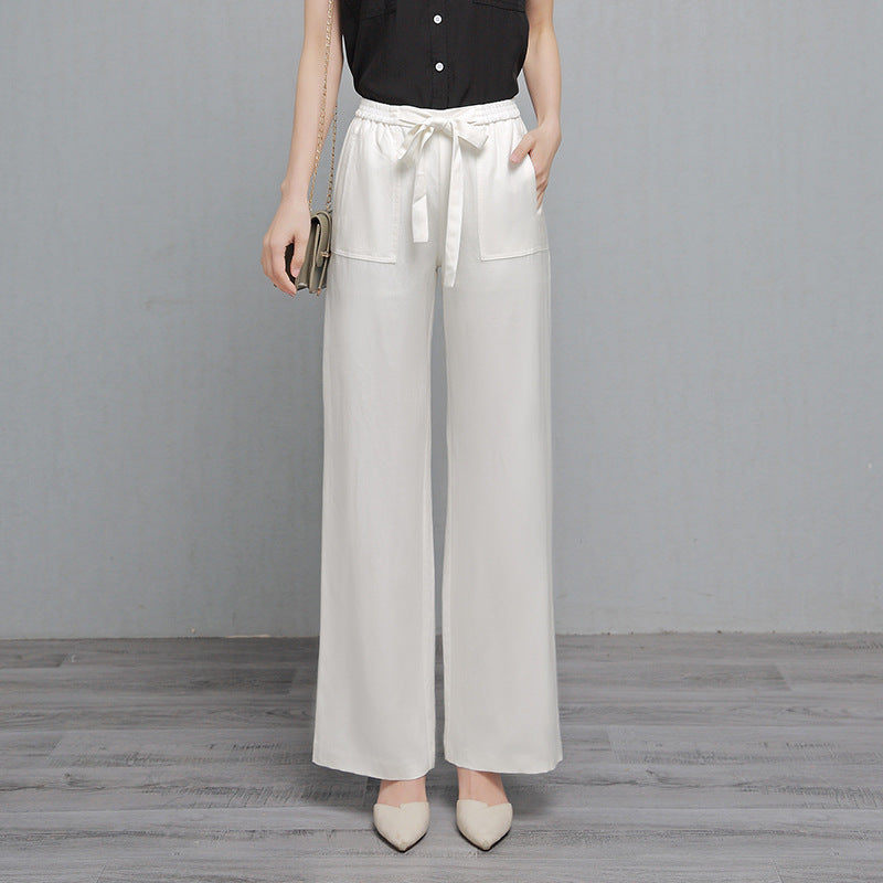 Person wearing light gray wide-leg pants with a plain background