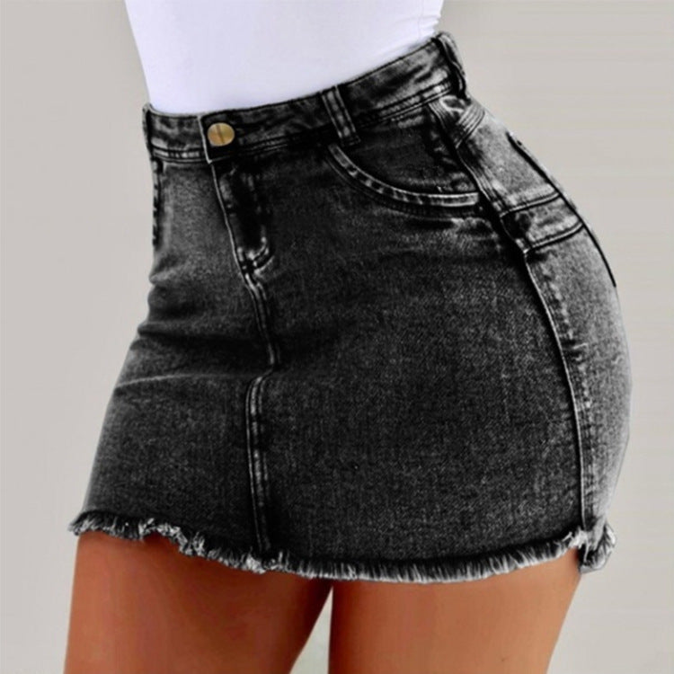 Black denim skirt worn by a person on a plain background