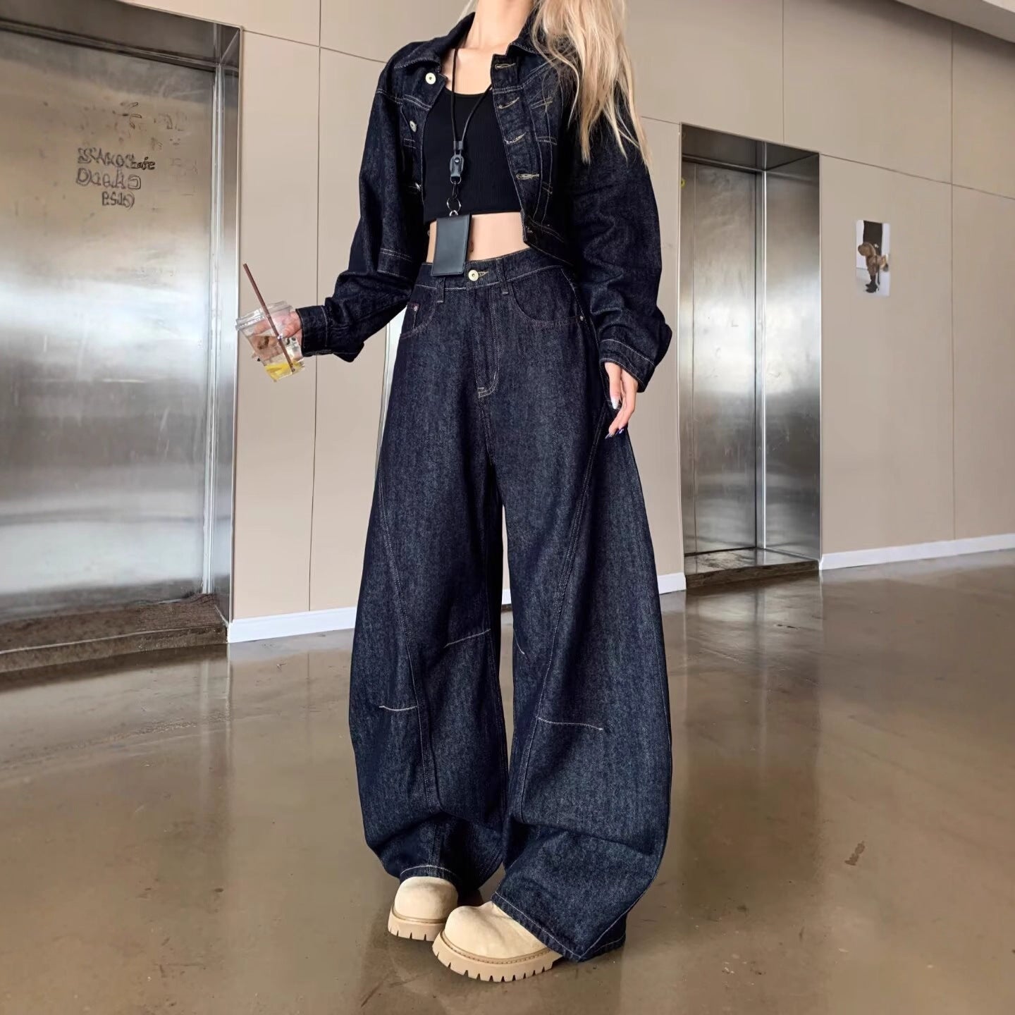 Person wearing a denim outfit in an indoor setting with elevators.