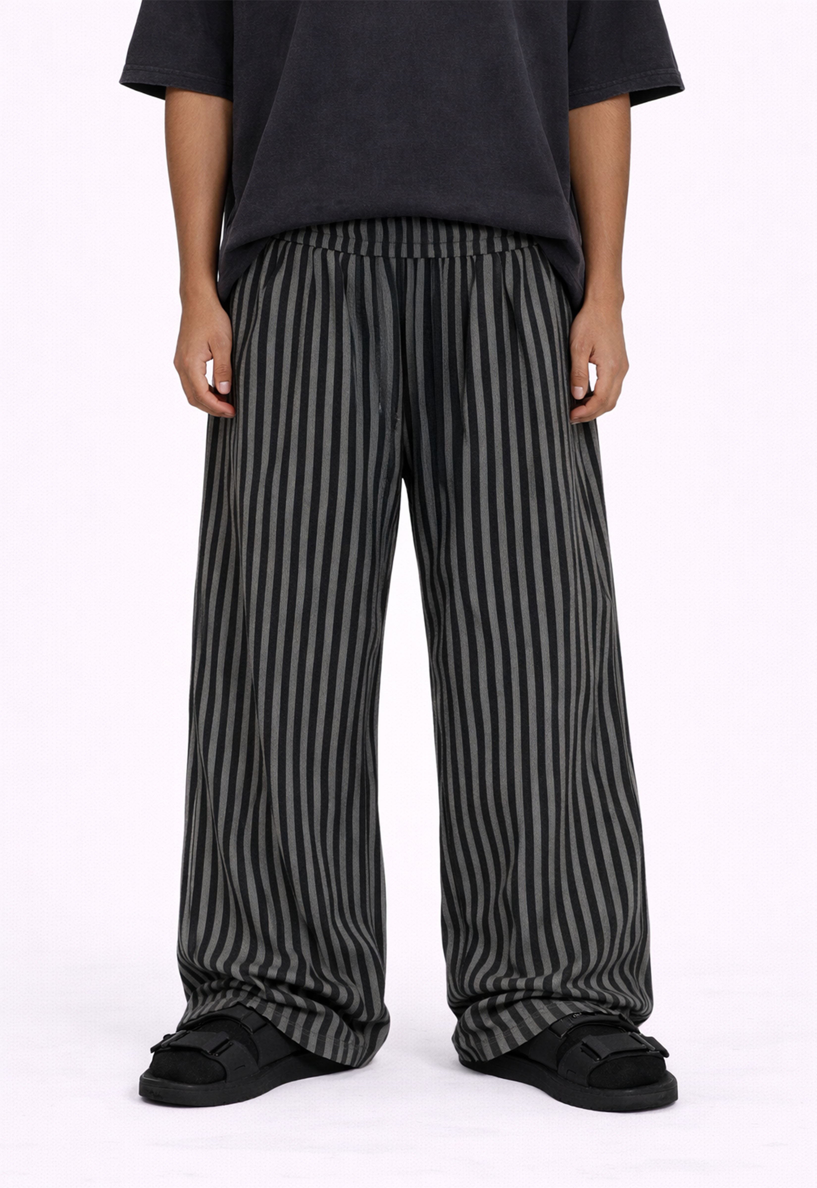 Person wearing black and gray striped pants on a white background
