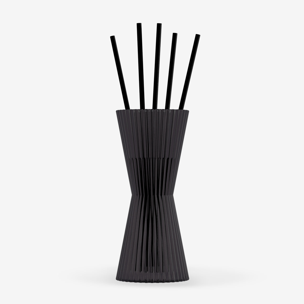 Black vase with ribbed design and six black sticks on a white background