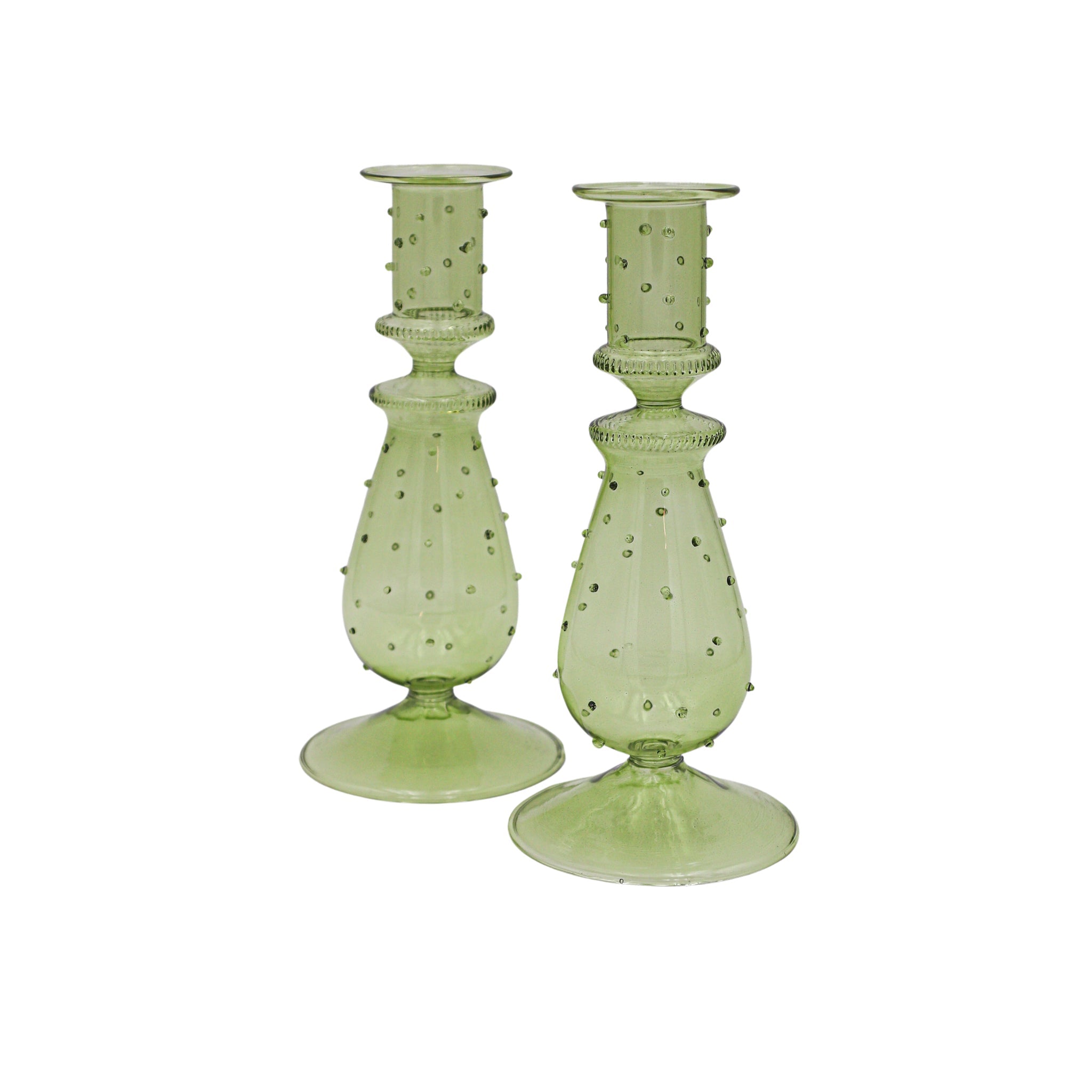 Two green glass candle holders with textured design on a white background